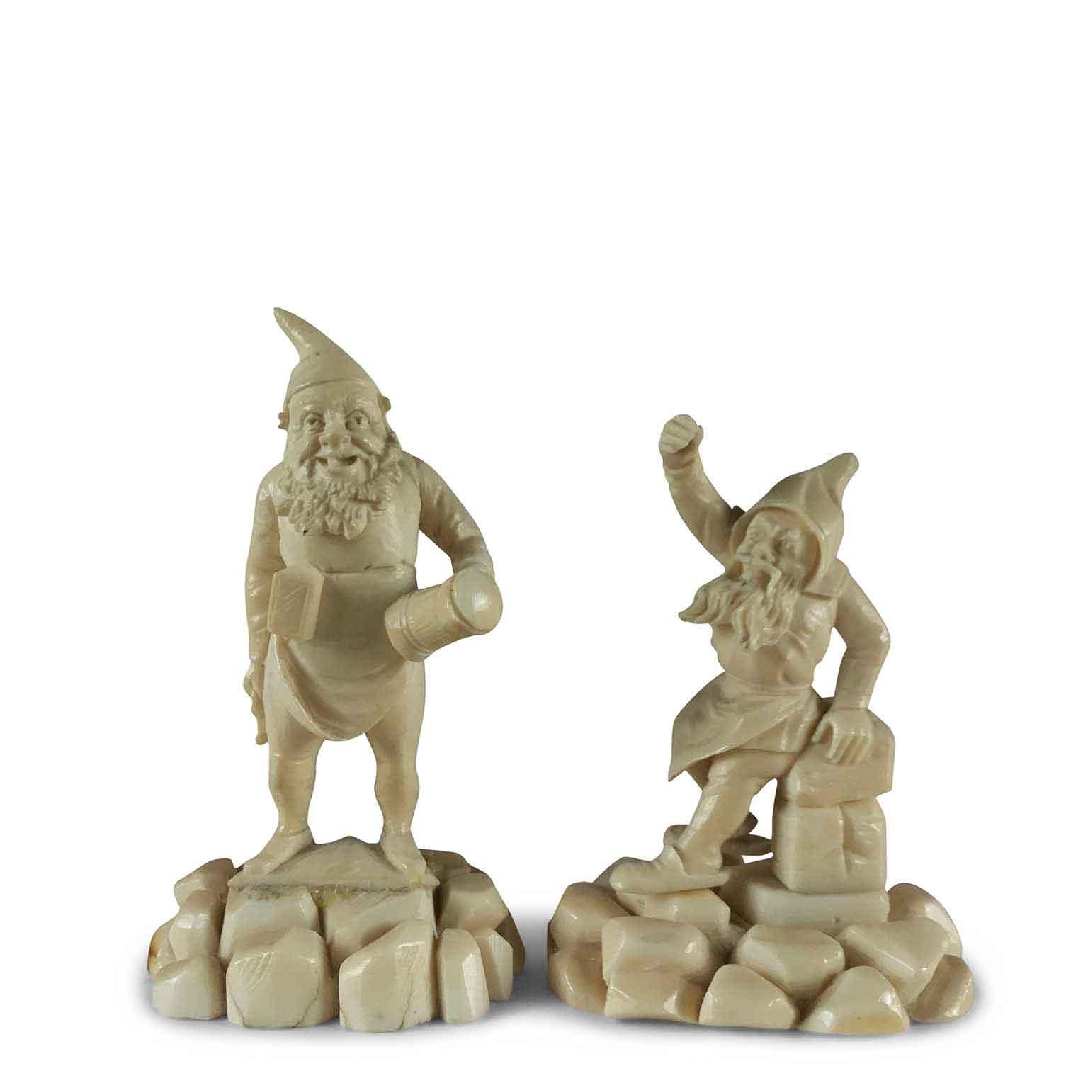 Lovely pair of cheerful gnome figurines carved bone gnomes of German origin dating back to the second half of the 19th century.
On a carved bone rocky pedestal, a standing smiling gnome holds a mug with a lid in one hand and a bunch of keys in the