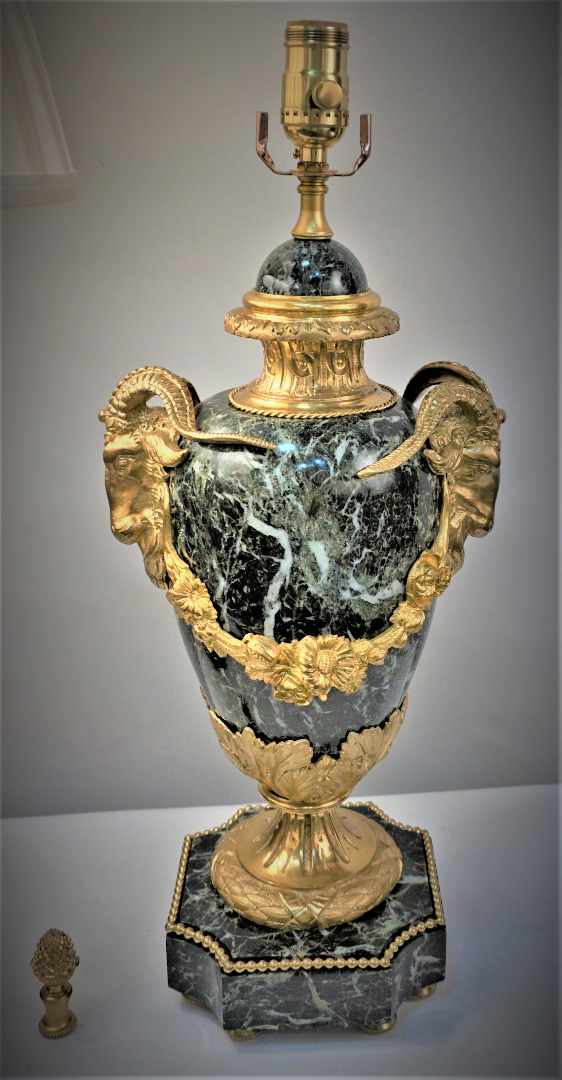 Air of 19th century marble urns with gilt rams' head bronze on each side that professionally have been electrified as table lamps and fitted with pleated silk lampshades.