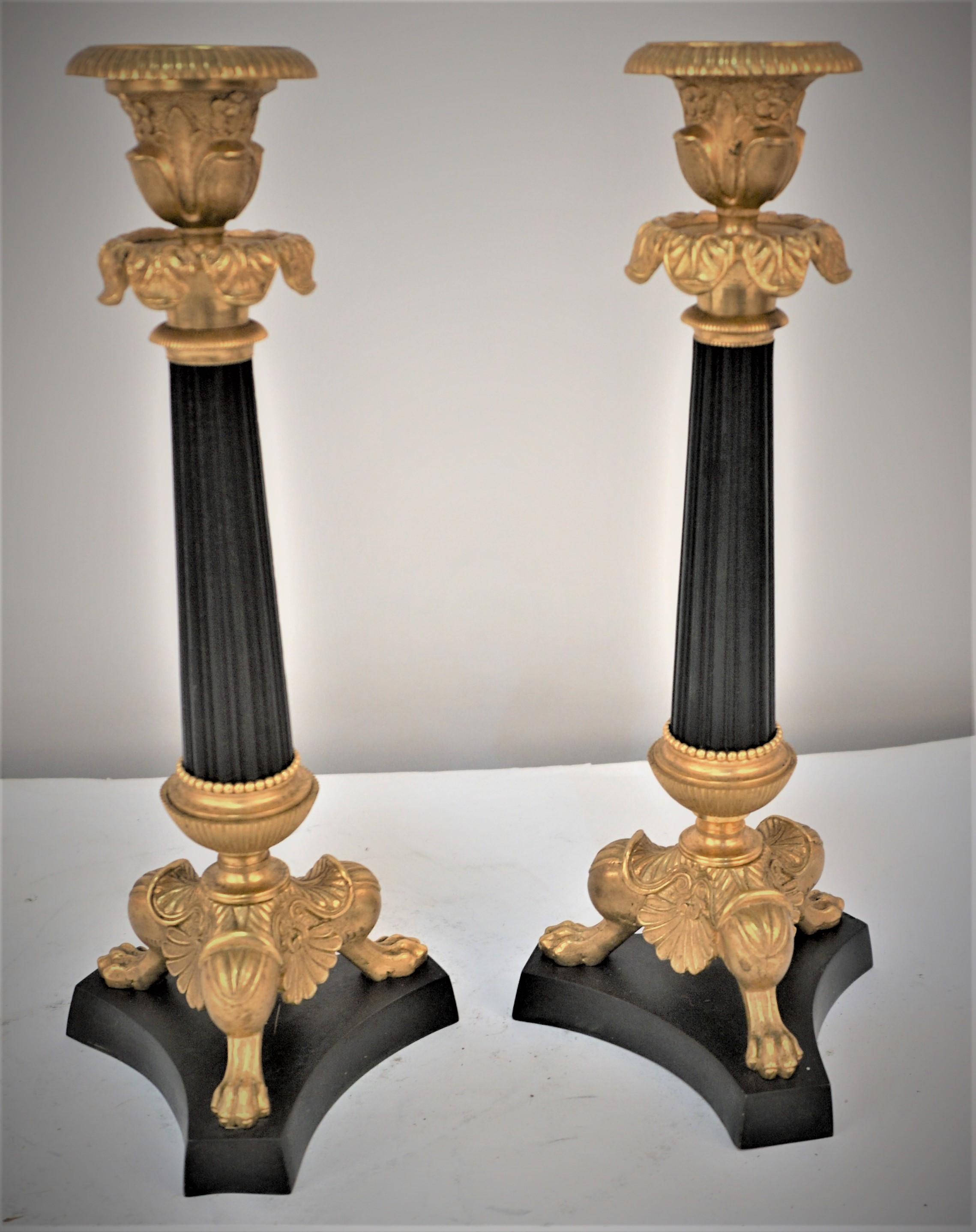 A pair of 19th century Regency gilt bronze and oxidized black candlesticks, with three lion's claws. #2.