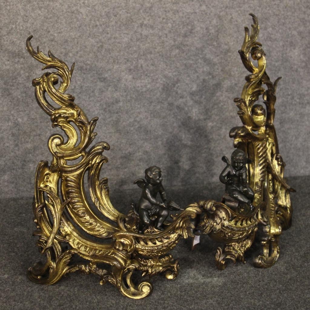 Pair of French firedogs from the late 19th century. Objects in gilded and chiselled bronze adorned with sculptures depicting winged cherubs. Great size and impact firedogs decorated with curled feet of excellent quality. Side fireplace decorations