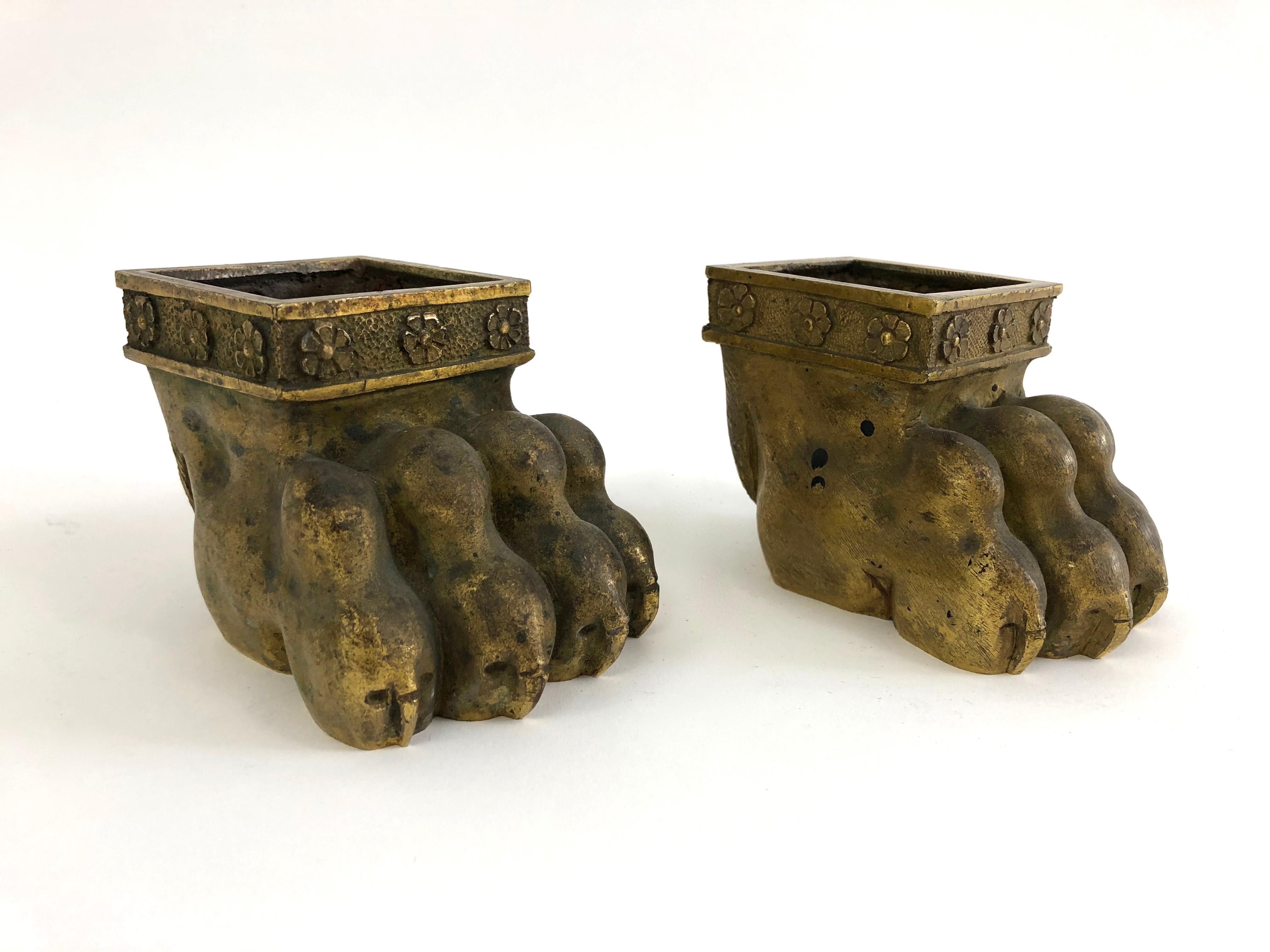 A highly decorative pair of 19th century neoclassical gilt bronze lion paw feet, made for Regency period table, chair or side cabinet. Each is boldly and naturalistically modeled and has a band of rosettes around the top. These unusual objects make
