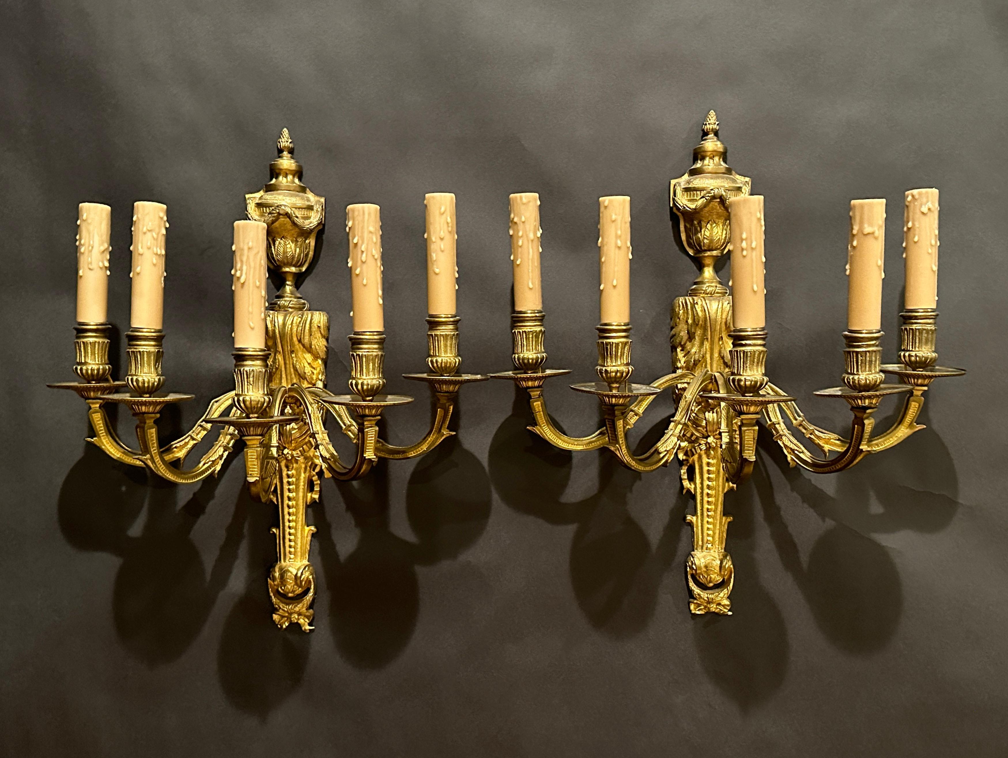 Pair of nice quality Louis XVI style gilt bronze original candlelight wall sconces. Five(5) arm with outside wiring and beeswax candle covers. Urn form with rope garland and acanthus leaf decorations in the traditional Louis XVI form.