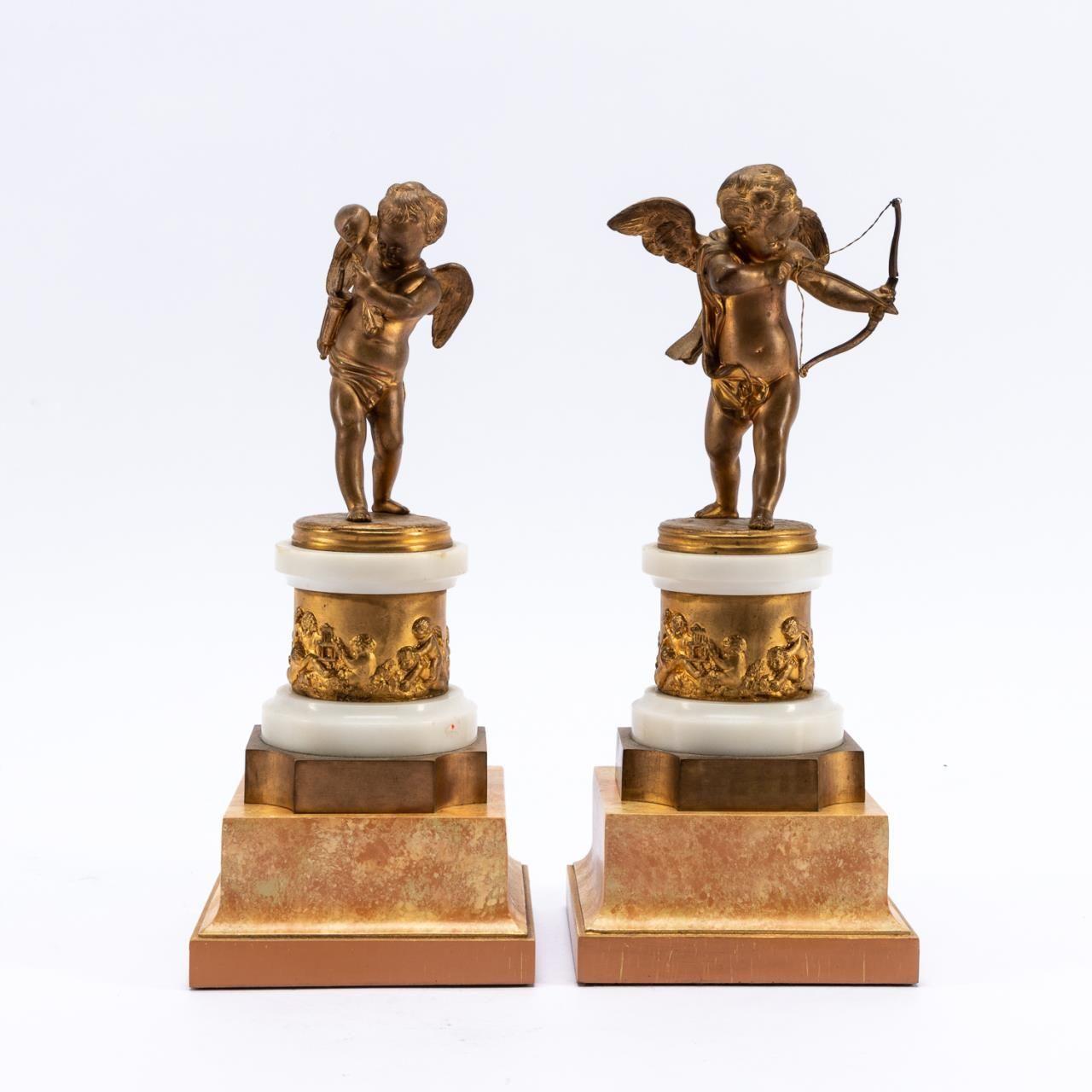 French, late 19th to early 20th century. Pair of gilt bronze cupid mantel statuettes, one with bow drawn and one removing an arrow, on white marble plinths with figural cherub plaques, with later faux marble wooden bases. Each signed in mould