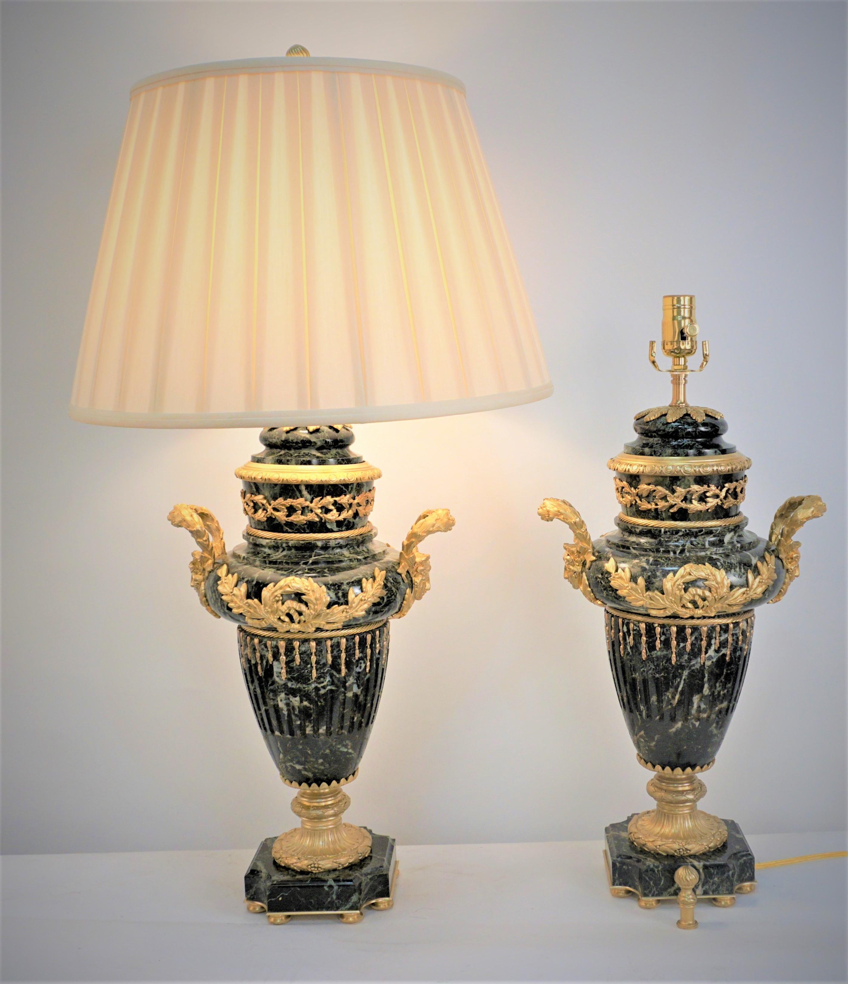 An exceptional pair of French 19th century gilt bronze over black marble with white and green vein urns that have been professionally electrified and have been made to and elegant pair of table lamps and fitted with box please silk lampshades.