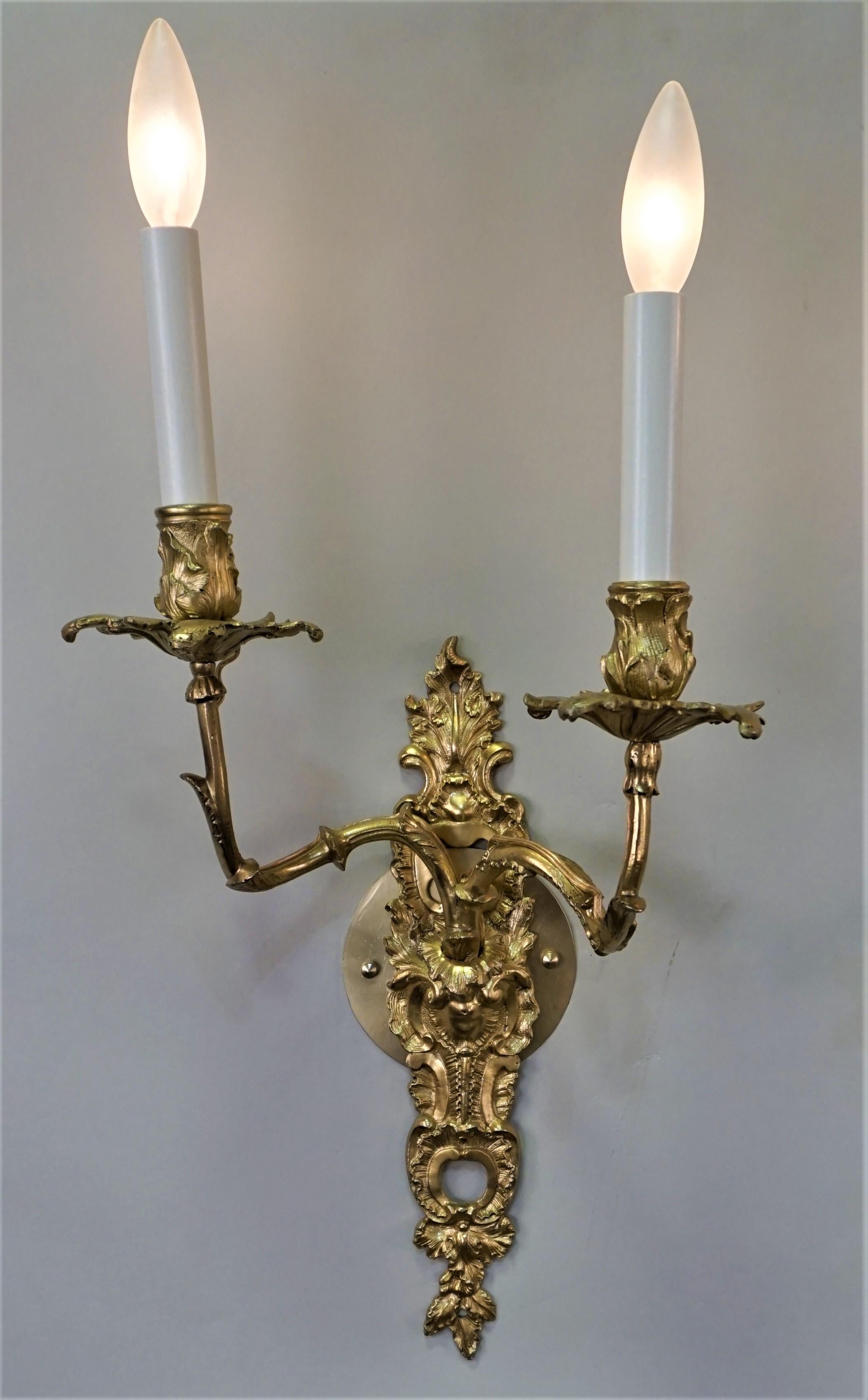 Pair of double arm gild bronze candle wall sconces that have been professionally electrified.