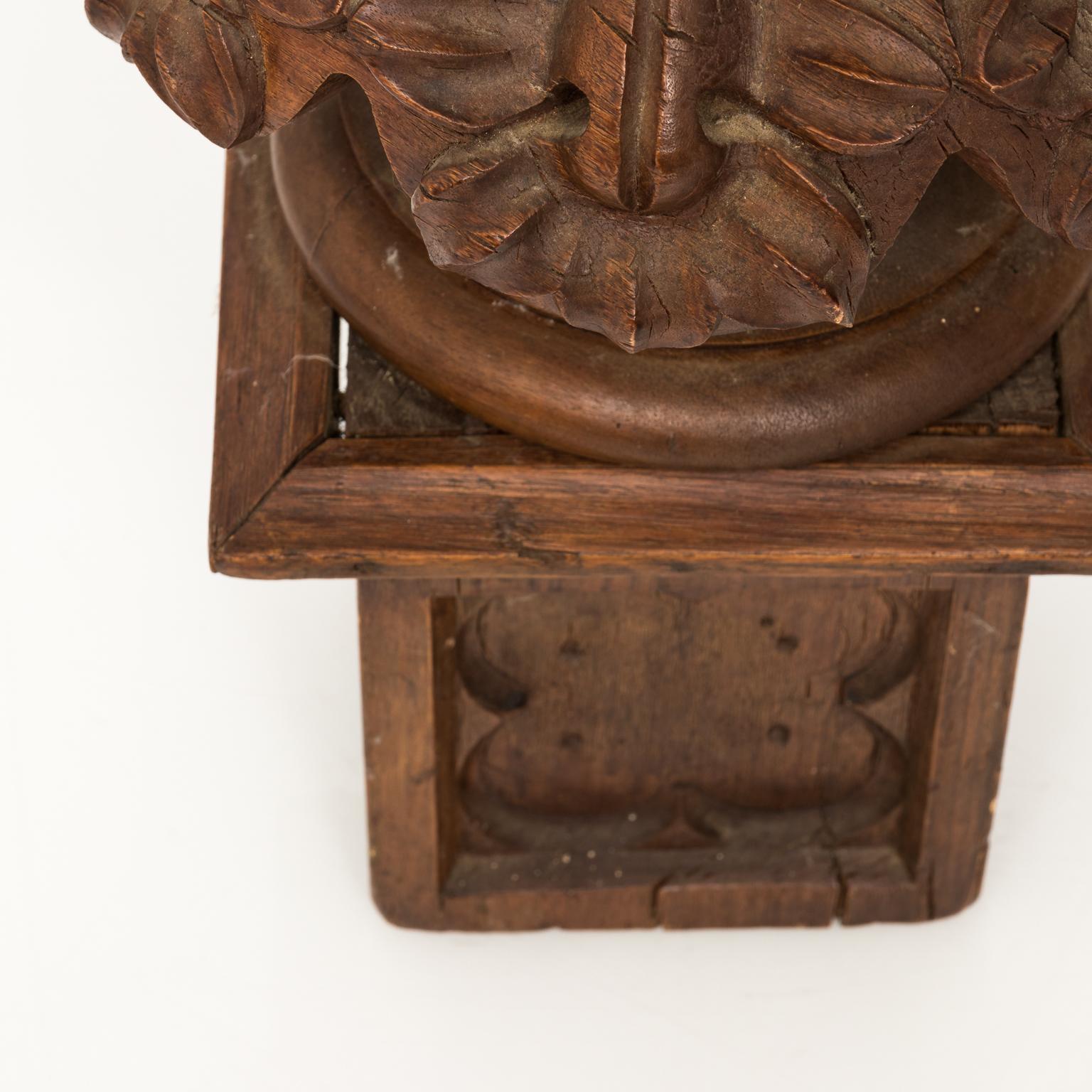Pair of early 19th century carved walnut finials with leaf motif, and square bases featuring quatrefoil motifs. These finials most likely were part of a wooden staircase railing or newel post. Cracks and small chips through out both pieces. Original