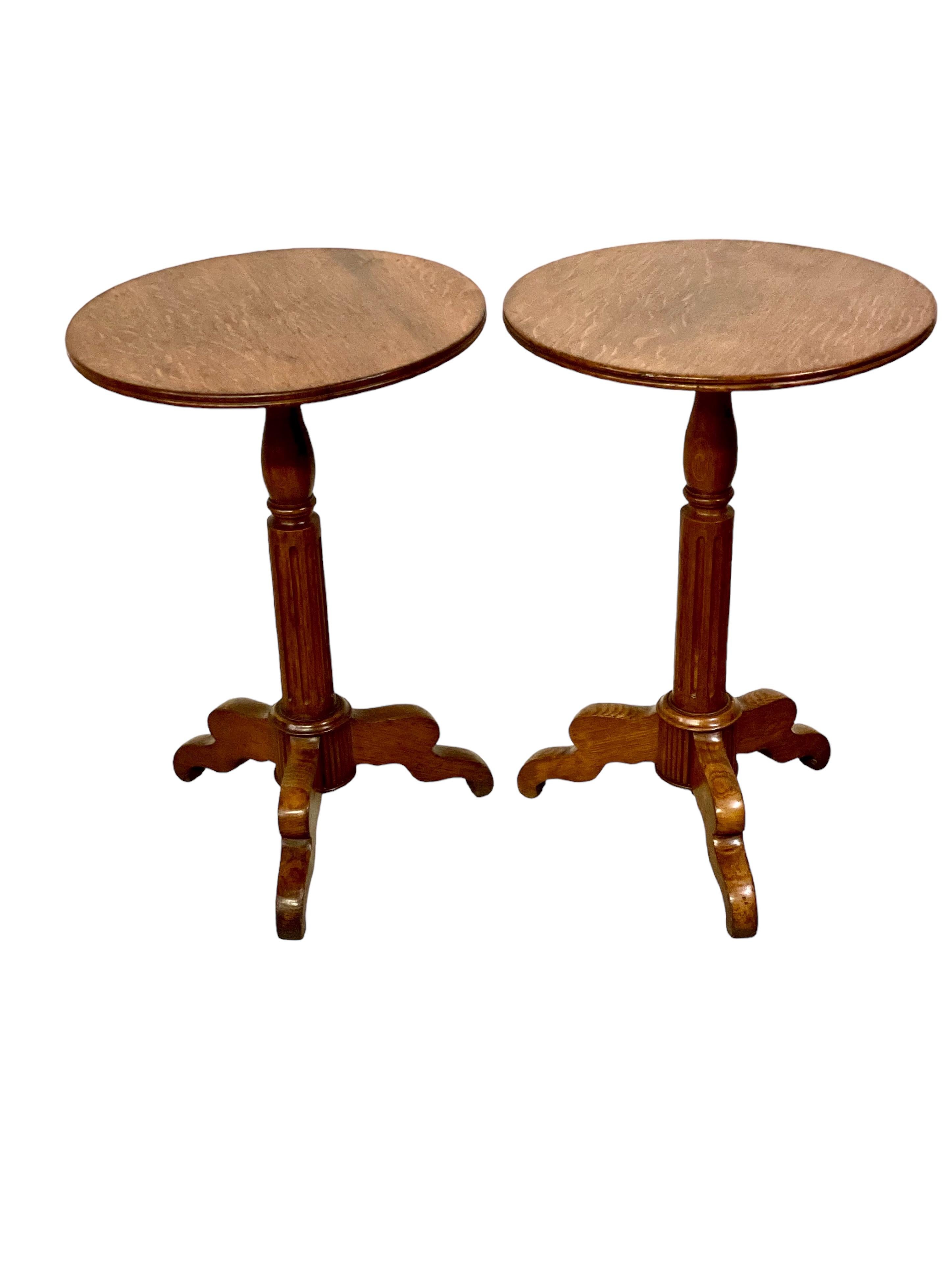 A charming pair of 19th century French occasional, or side, tables in walnut. These beautifully polished and supremely practical 'guéridon' tables each feature a one-piece circular top with a moulded edge, and sit above a central turned and fluted