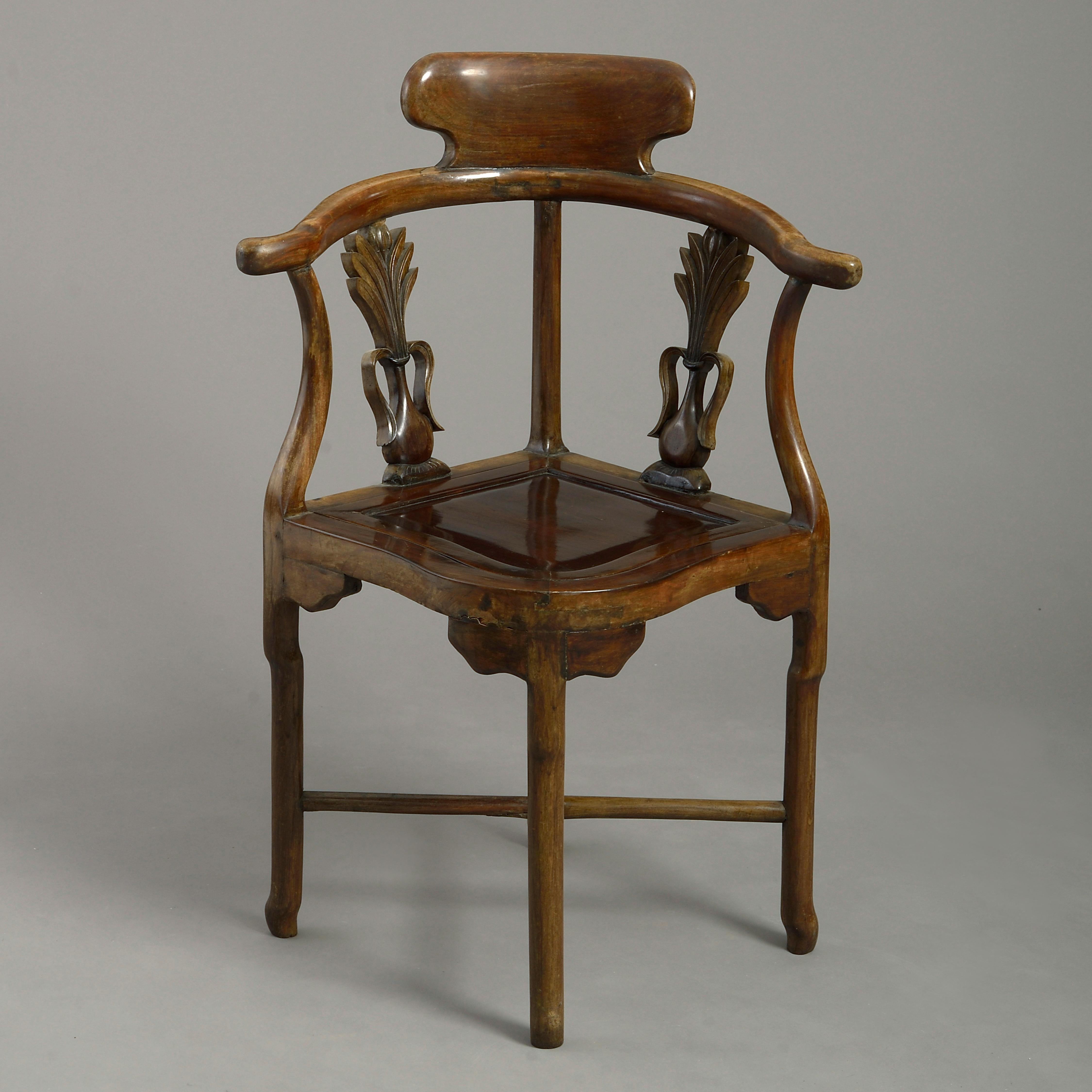 A pair of 19th century hardwood corner armchairs, each having a horseshoe back rail above two carved vase splats with stylized foliage, the drop-in wooden seats all raised on shaped legs with X-form stretchers.