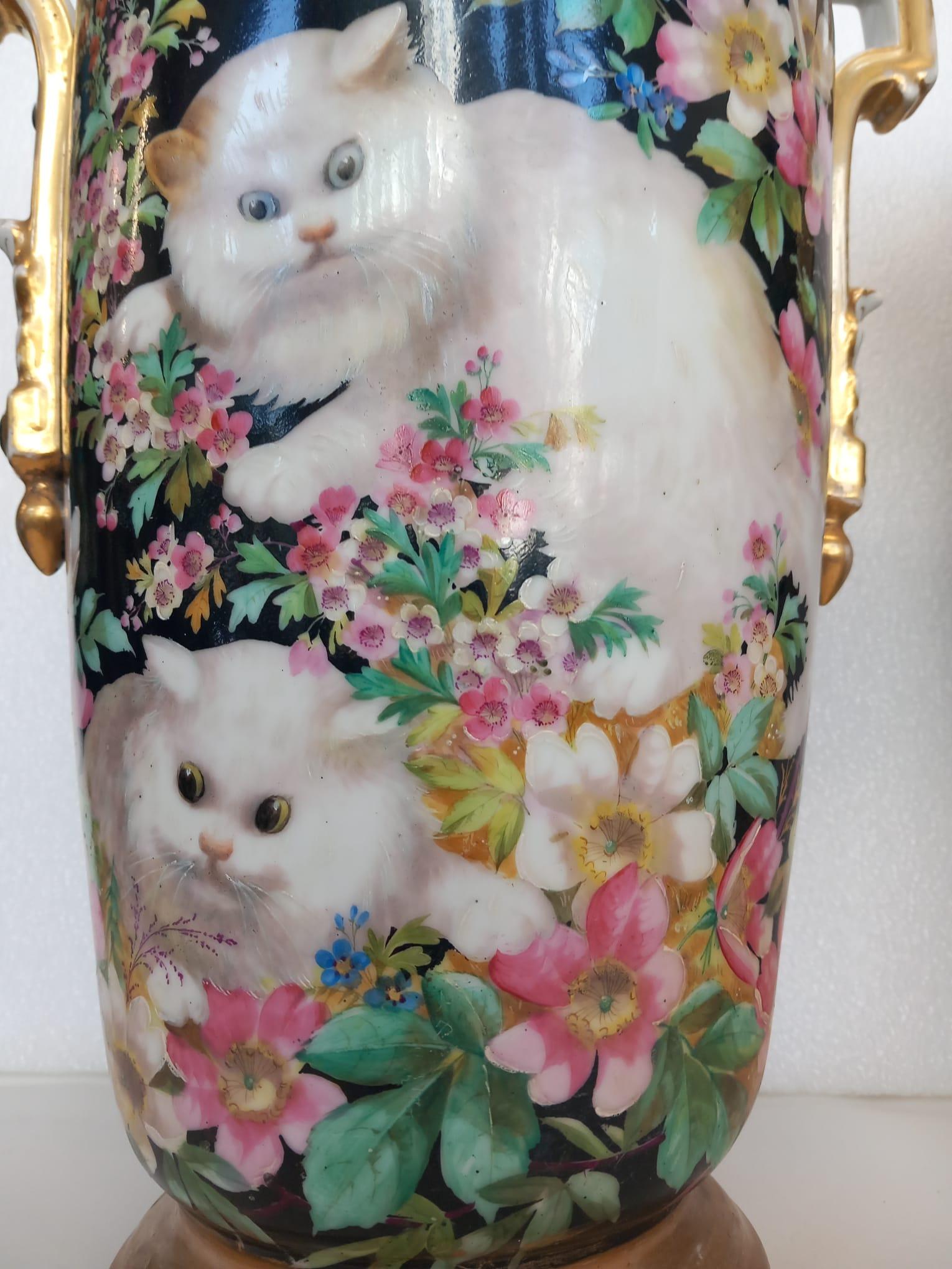 Pair of Paris two handled vases, delicately painted with kitten amongst flowers on a bluish ground, painted all around with a variety of coloured flowers.