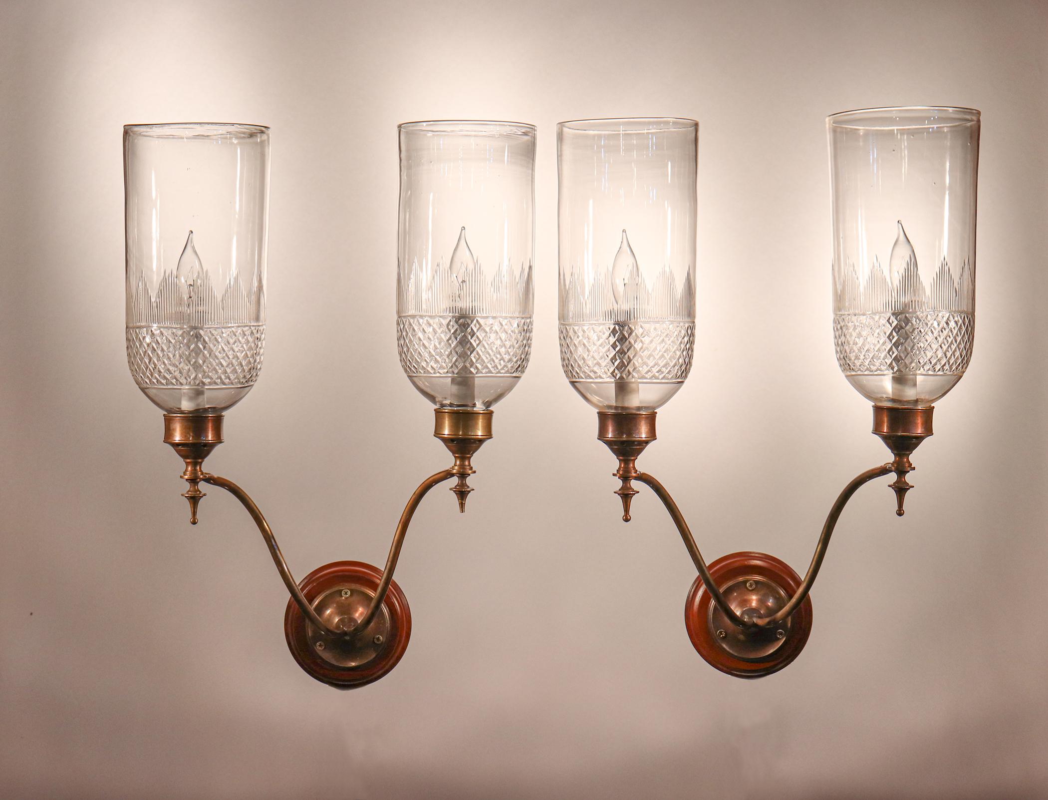 A rare set of four Classic English hurricane sconce shades with cut-glass etching at their bases. The quality of these circa 1900 shades is very good, with several desirable air bubbles in the hand blown glass. The shades arrive ready to install