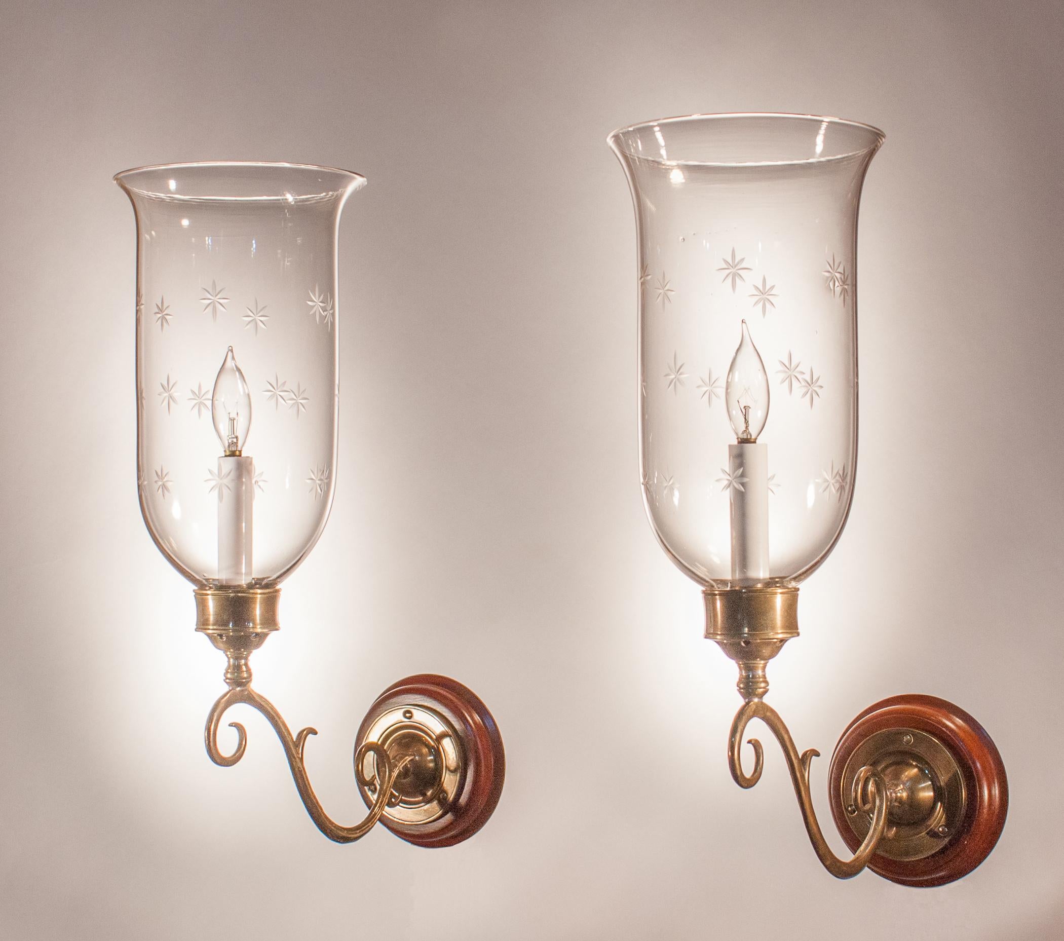 A pair of English hurricane sconce shades with delicately flared form and an etched star motif. The quality of these circa 1880 hand blown glass shades is excellent. They have been newly electrified with a single candelabra bulb up to 60 watts.