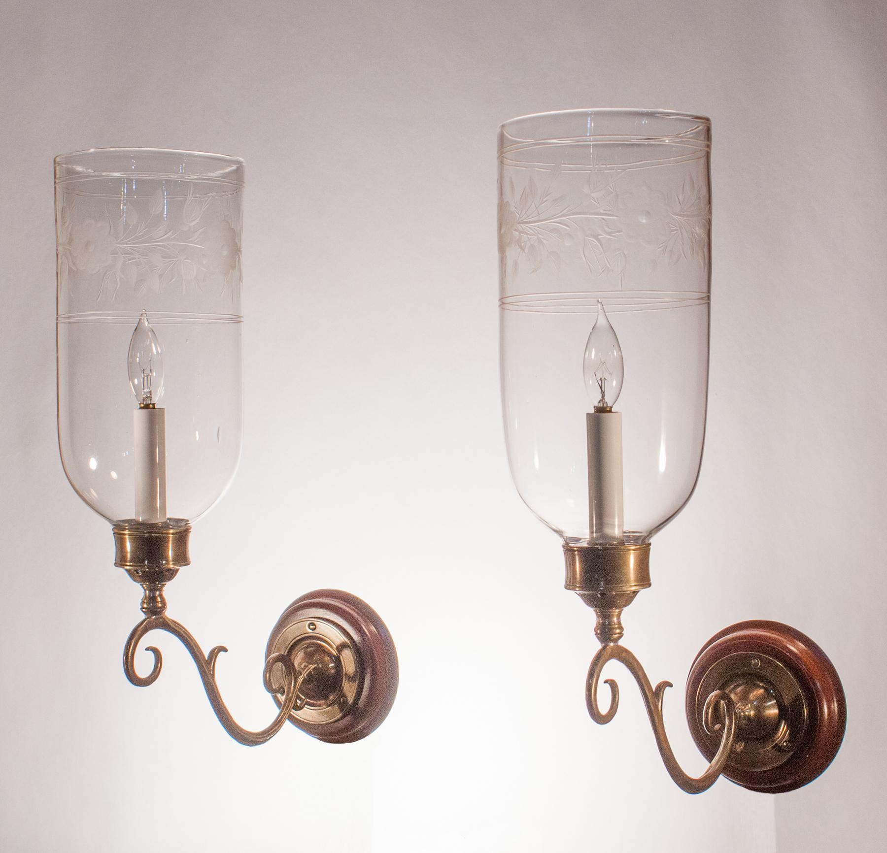 A beautiful pair of hurricane sconce shades with straight form and a tasteful flower and vine etched motif. The quality of these circa 1890 shades is very good, with desirable air bubbles in the hand blown glass. The wall sconces have been newly