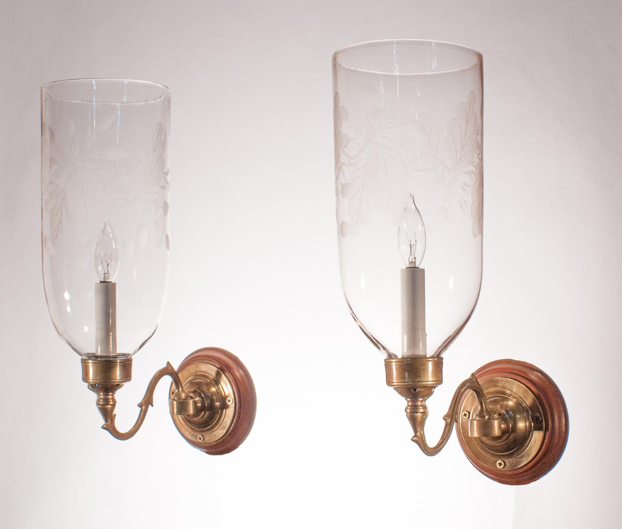 A beautiful pair of late 19th century hurricane shades with straight form and a tasteful frosted leaf motif. The quality of the handblown glass is excellent, with some subtle swirling in the glass. Originally for candles, the wall sconces have been