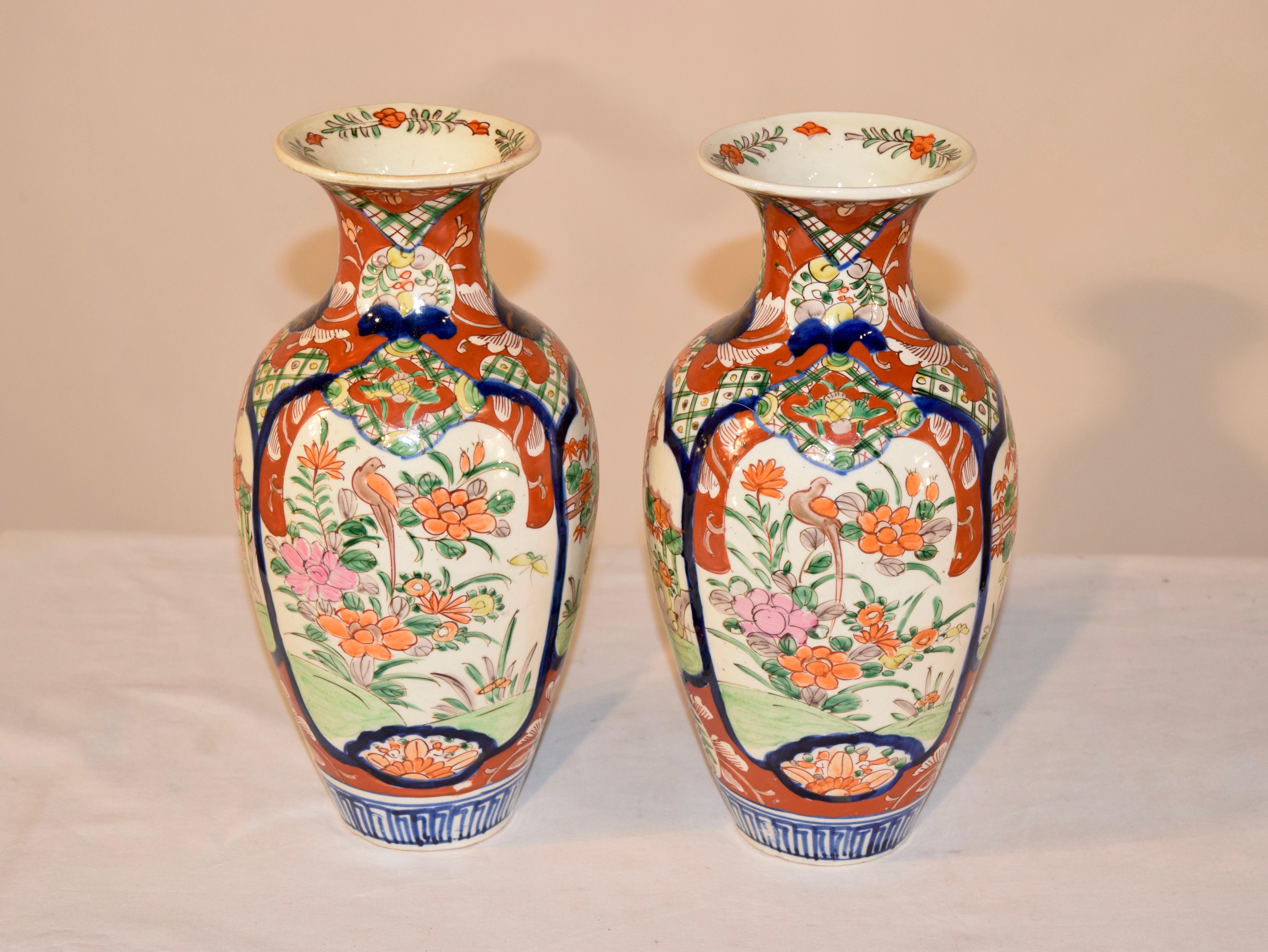 Pair of 19th century Imari vases with flared collars and wonderfully bulbous shapes which taper at the bottom. They are hand painted and have large medallions on the front and back, both with depictions of birds on branches with florals. The larger