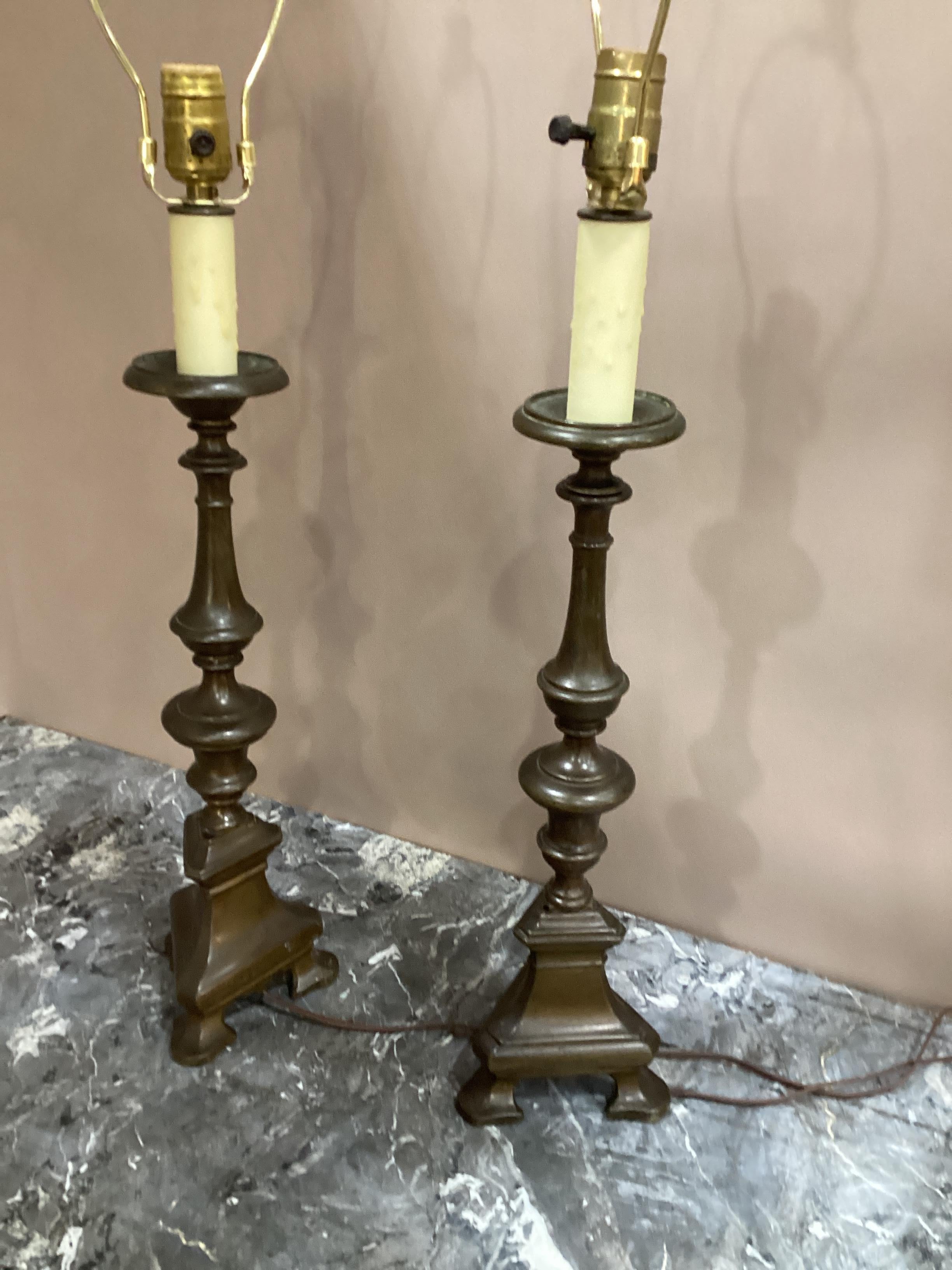 Pair of 19th Century Italian Baroque Style Bronze Candlesticks converted into lamps. Measures 21” to bottom of harp and 30” overall. Wired and in good working condition.