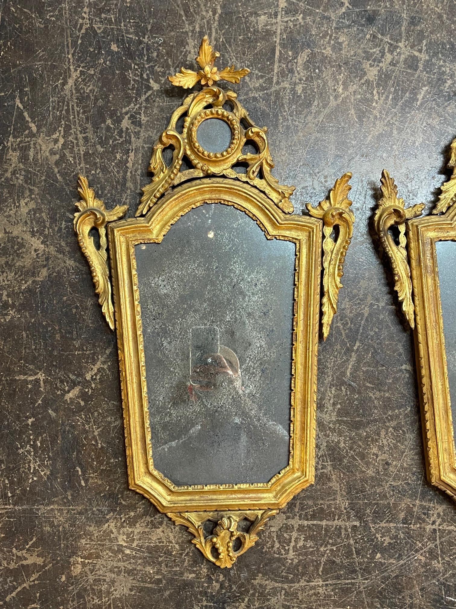 Beautiful pair of 19th century Italian carved and painted giltwood mirrors. Fine carvings including floral images with a small mirror inside at the top. Wonderful accessories for a fine home!