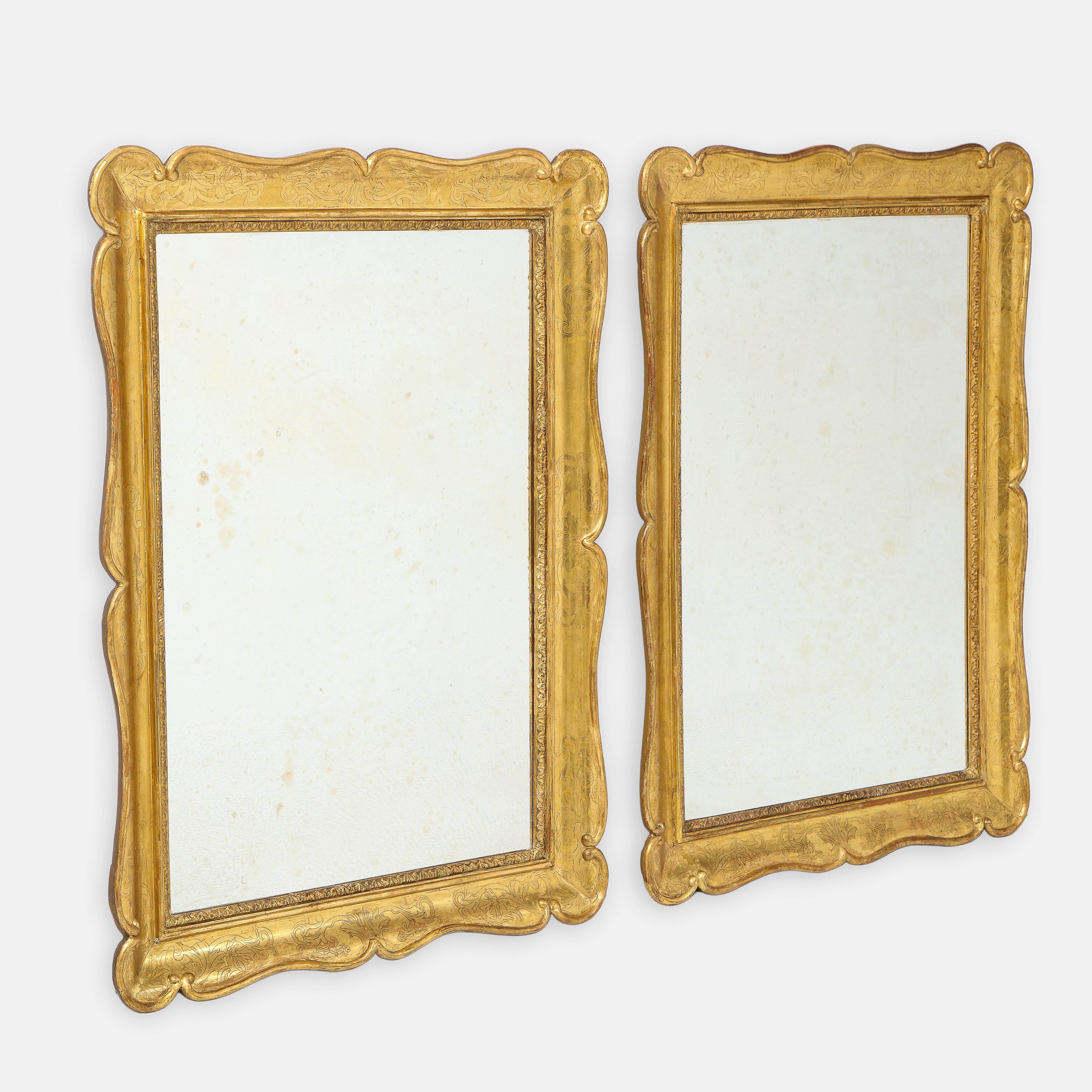 Paire d'exquis miroirs rectangulaires italiens en bois doré sculpté du XIXe siècle. Chaque miroir conserve la plupart de sa finition originale et riche en satin doré, avec des bords délicatement sculptés et des feuilles d'acanthe finement sculptées