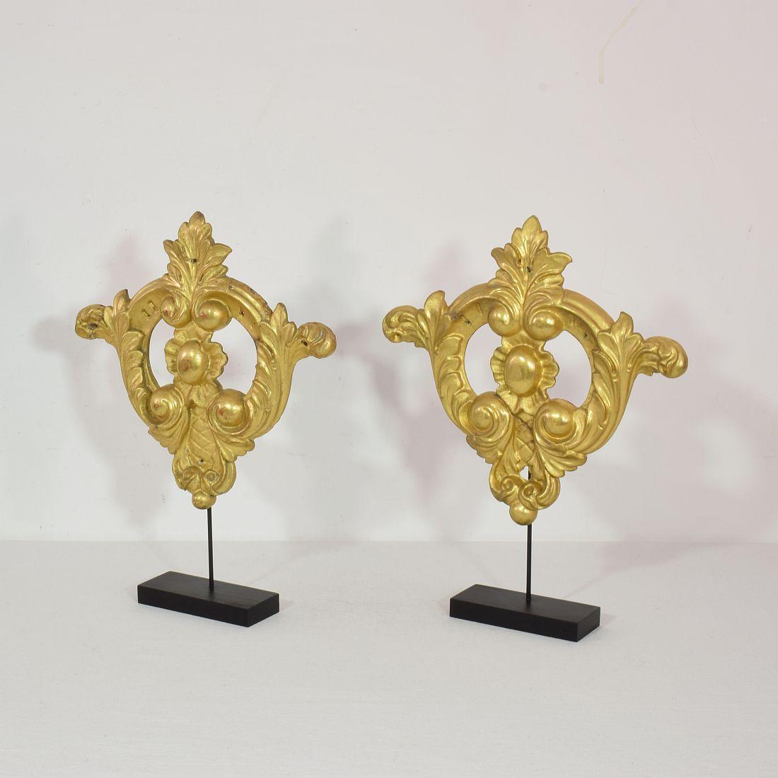 Nice couple of two gilt-wood ornaments in baroque style,
Italy, circa 1850. Weathered and old repairs. Measurement here below includes the wooden base.
