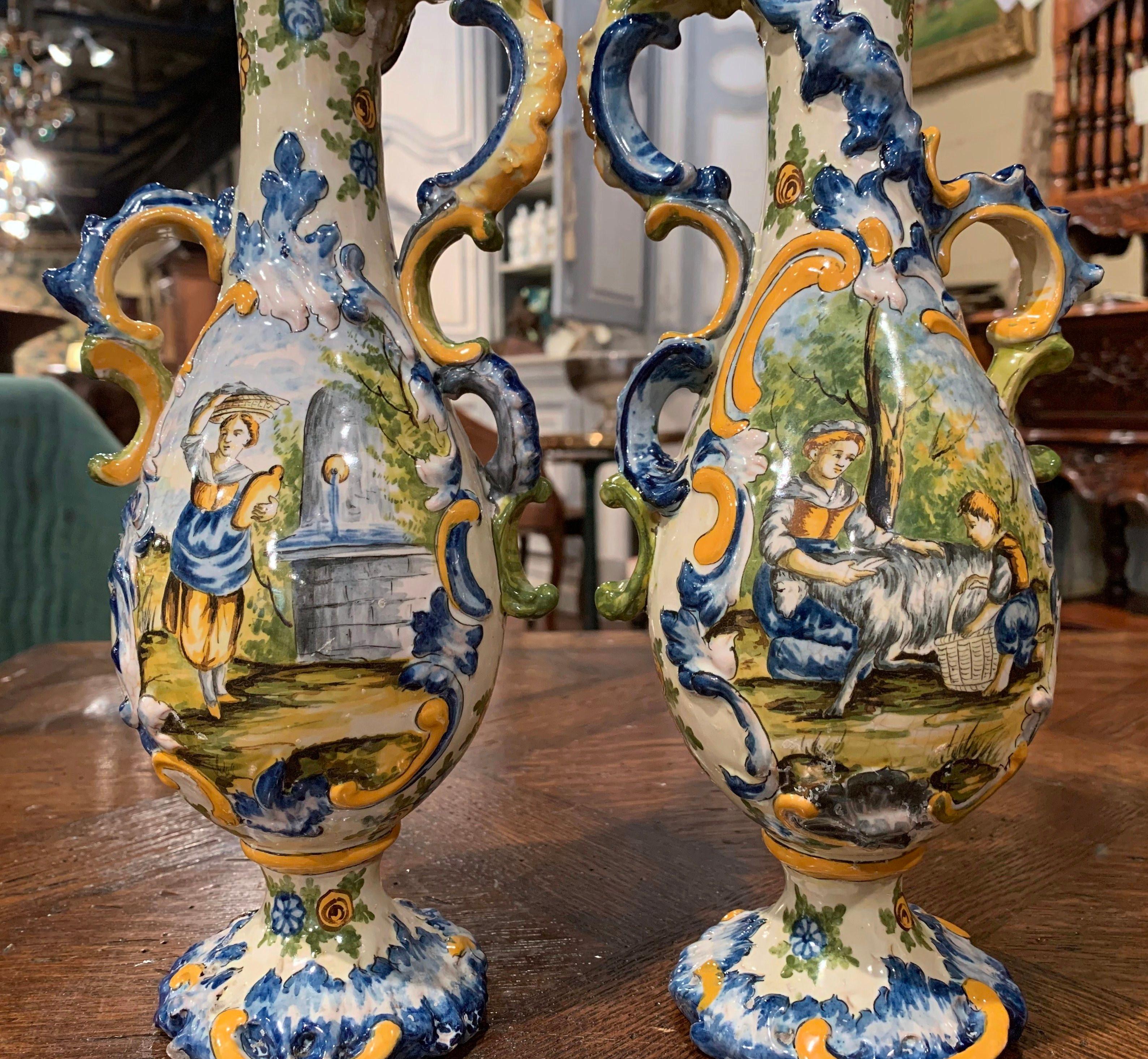 Make a statement on a mantel (fireplace) or enfilade with this pair of sculptural, antique urns. Sculpted in Italy circa 1890, the artful, ceramic vases have a unique, asymmetrical shape and detailed illustrations. Crafted from porcelain, each