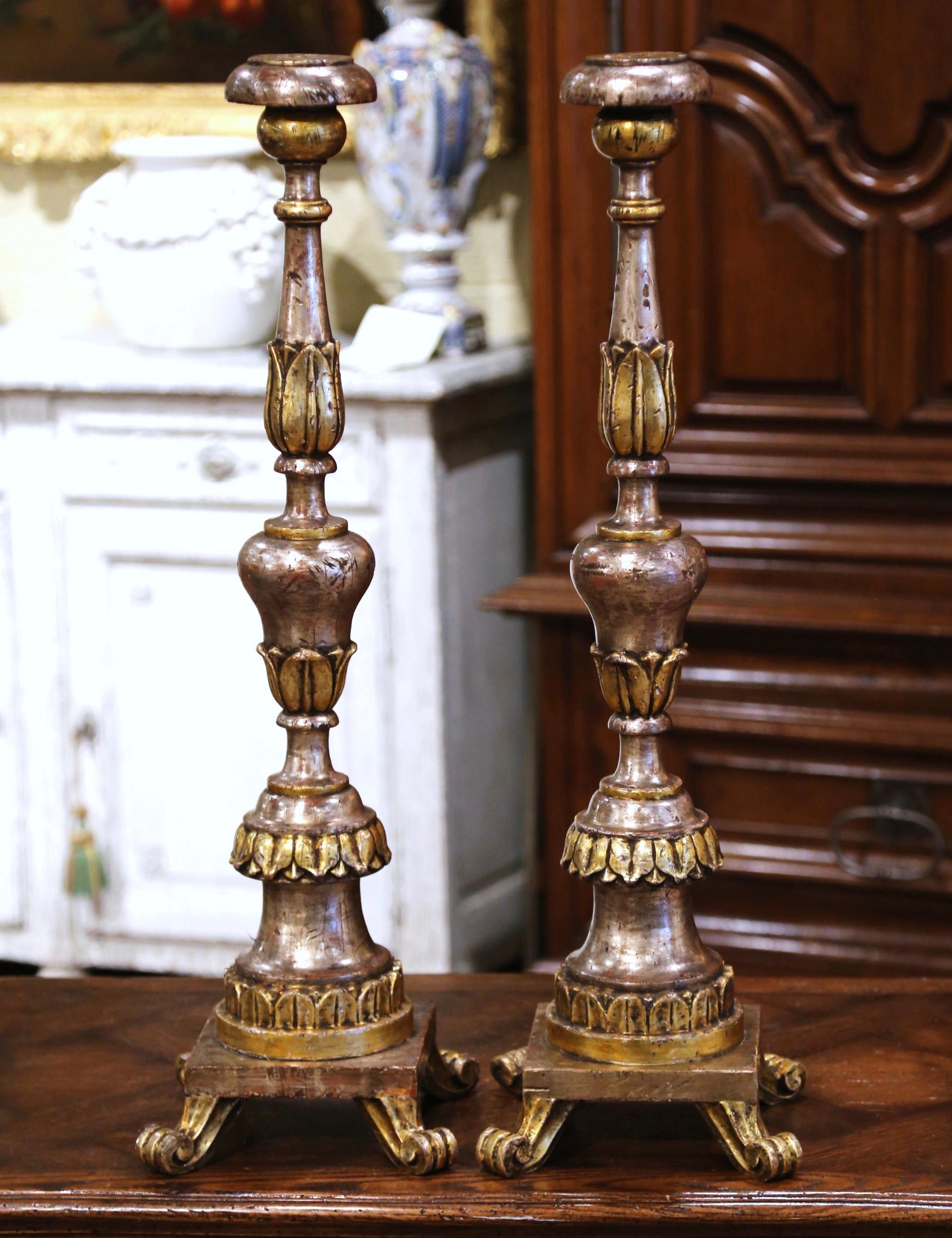 These elegant antique Pic-Cierges were created in Italy circa 1880. Standing on four scrolled feet over a square base, each tall candlestick features a carved stem decorated with acanthus leaf and foliage motifs throughout. The dramatic, embellished