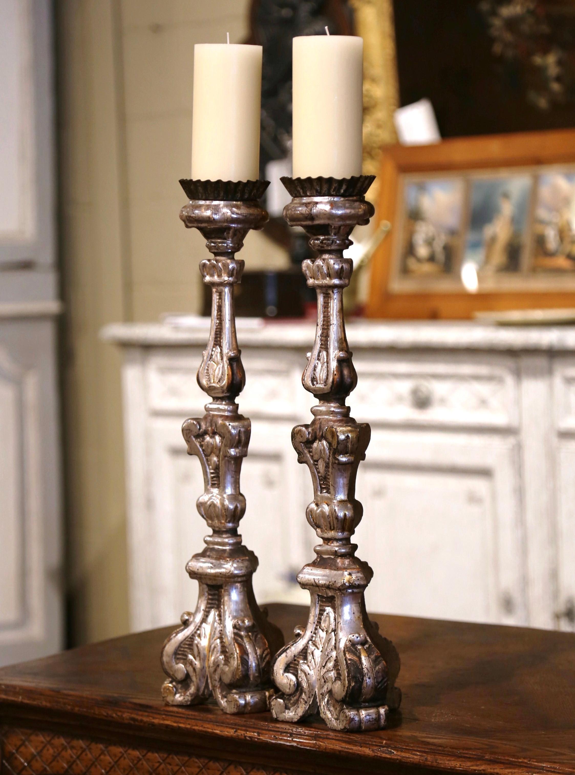 Add an air of elegance to your home with this pair of antique candlesticks. Crafted in Italy circa 1880, each candle holder stands on a sturdy triangle base decorated with hand carved acanthus leaf motifs over a carved stem embellished with foliage