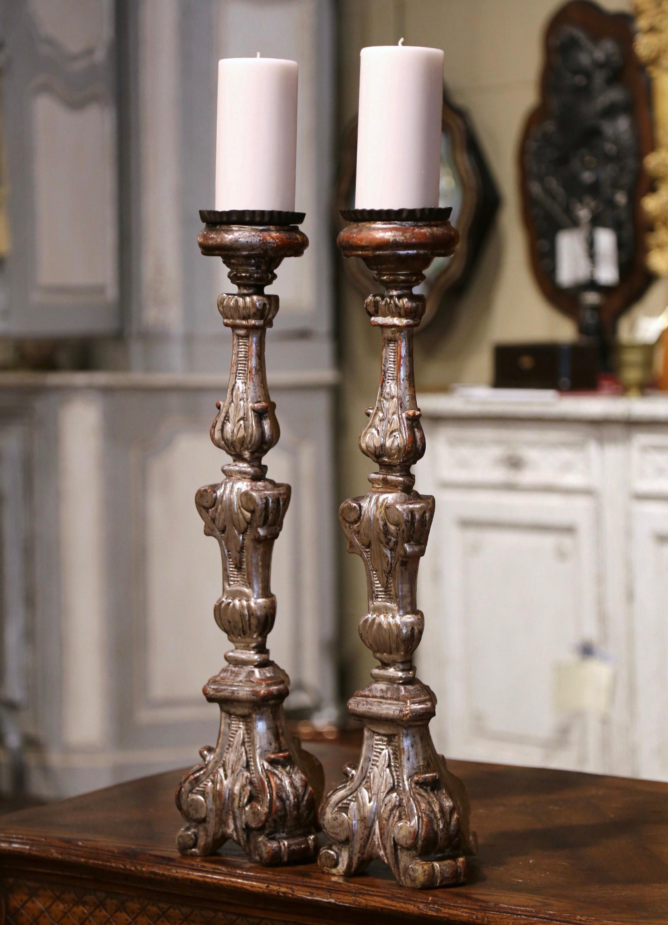 Add an air of elegance to your home with this pair of antique candlesticks. Crafted in Italy circa 1880, each candle holder stands on a sturdy triangle base decorated with hand carved acanthus leaf motifs over a carved stem embellished with foliage