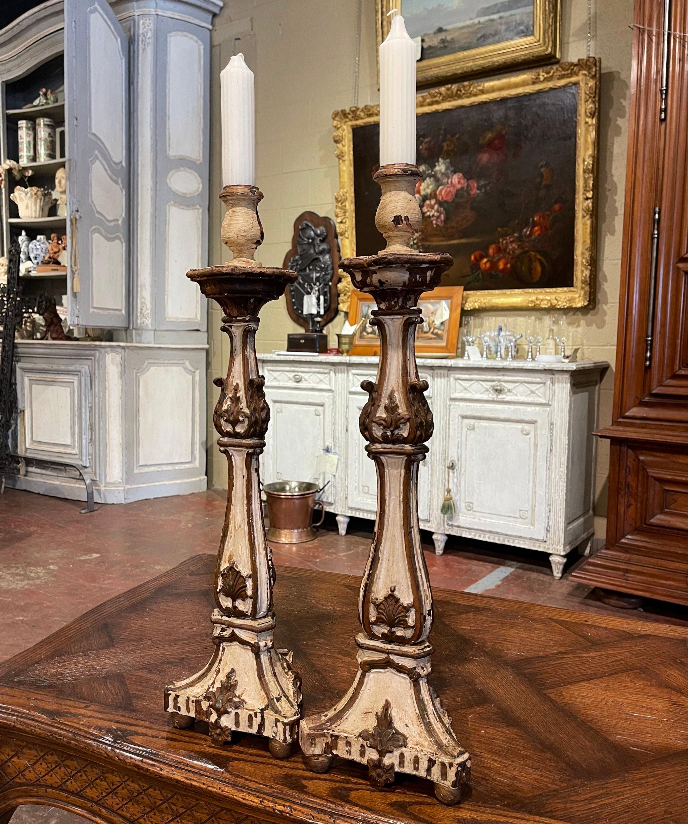 Bringen Sie mit diesem Paar antiker Kerzenständer einen Hauch von Eleganz in Ihr Zuhause. Die um 1880 in Italien gefertigten Kerzenhalter stehen auf runden Füßen auf einem stabilen dreieckigen Sockel, der mit handgeschnitzten Blumenmotiven verziert