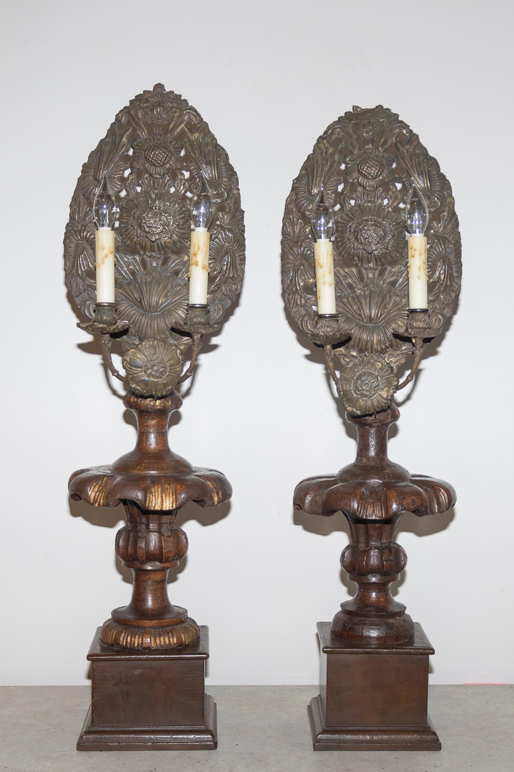 Fabriquée à la main dans l'Italie du XIXe siècle, cette étonnante paire de chandeliers en bois sculpté témoigne de l'art et de l'élégance de l'époque. Conçues à l'origine comme prunelles d'autel, ces pièces ont été soigneusement transformées en
