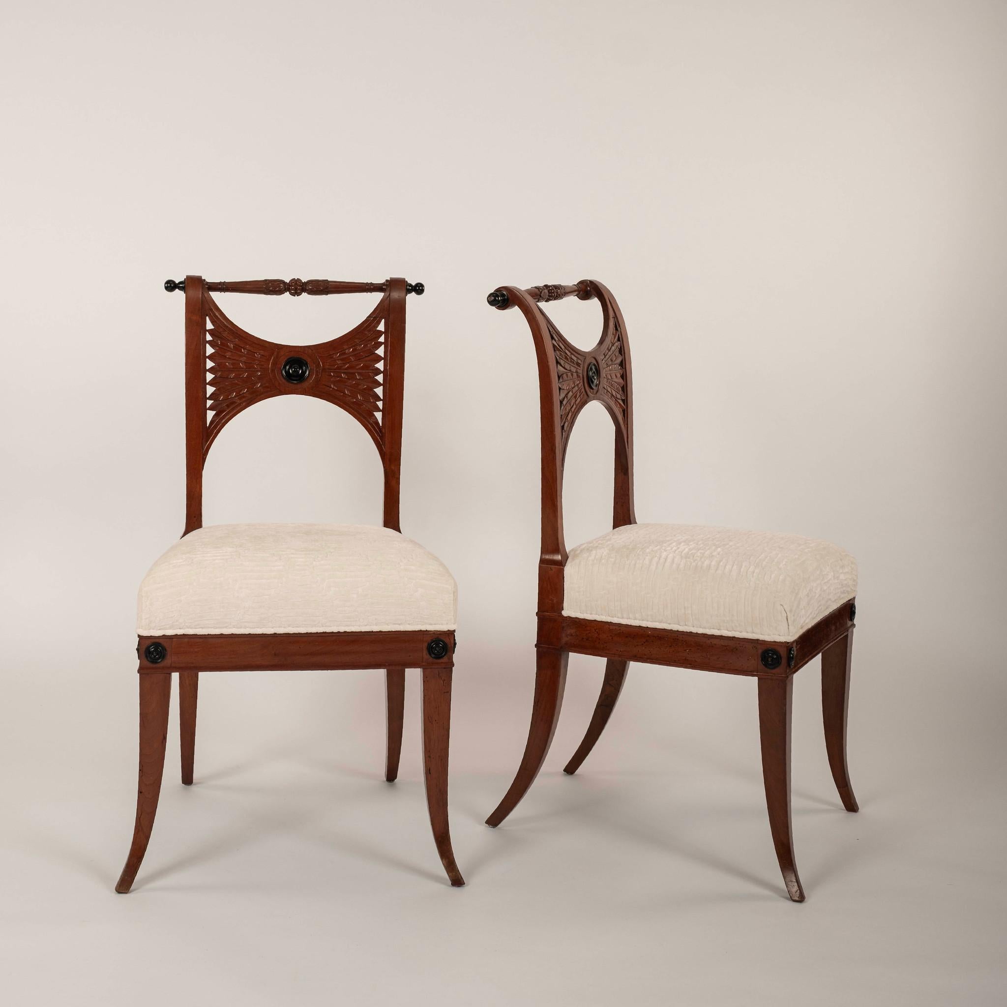 Paire de chaises d'appoint Empire italiennes du XIXe siècle, avec dossier sculpté de feuillages, médaillon central ébonisé et pieds élégamment incurvés. 

Deux paires disponibles, vendues par paire.