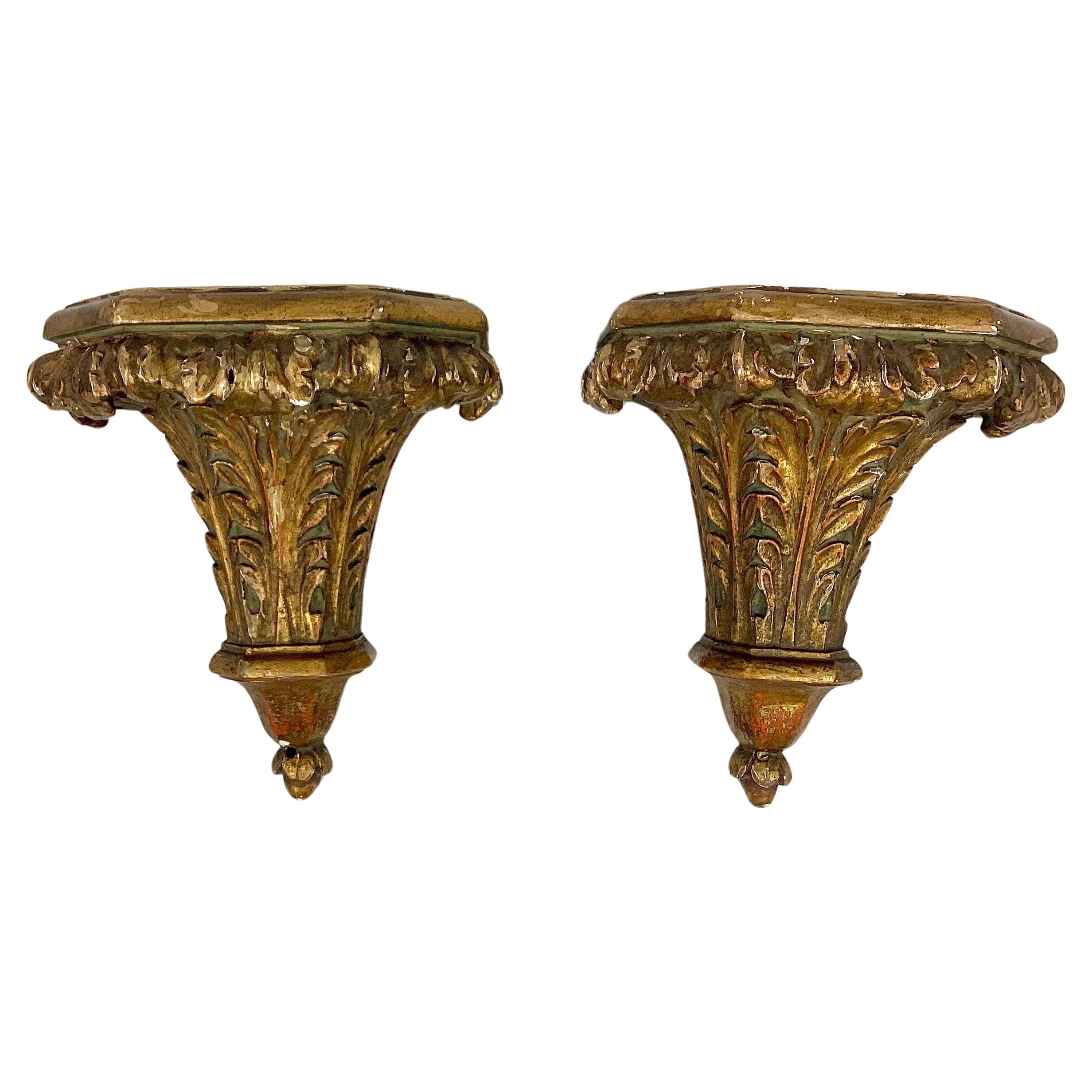 Pair of 19th century Italian gilt wall brackets. Brackets have beautifully carved and painted acanthus leaves topped with a flat shelf. Wonderful old patina. Brass hardware is affixed to back for hanging. 