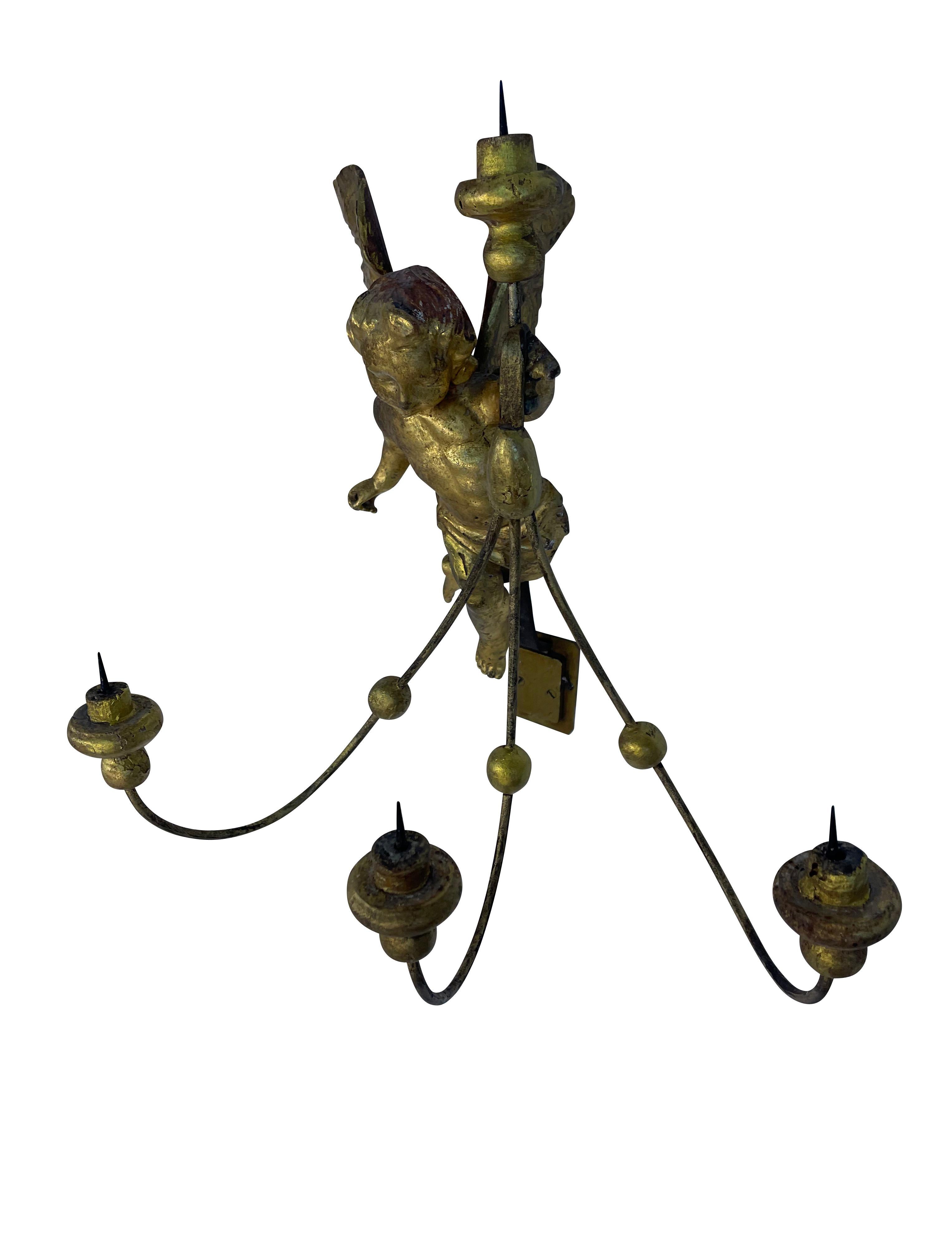 Pair of unusual 19th-century Italian gilt putti four-arm candle sconces.  These hand-crafted gilt winged putti /angels are a charming addition to any room. They are incredibly well-made with their own brass mounting plates.  There are three curved