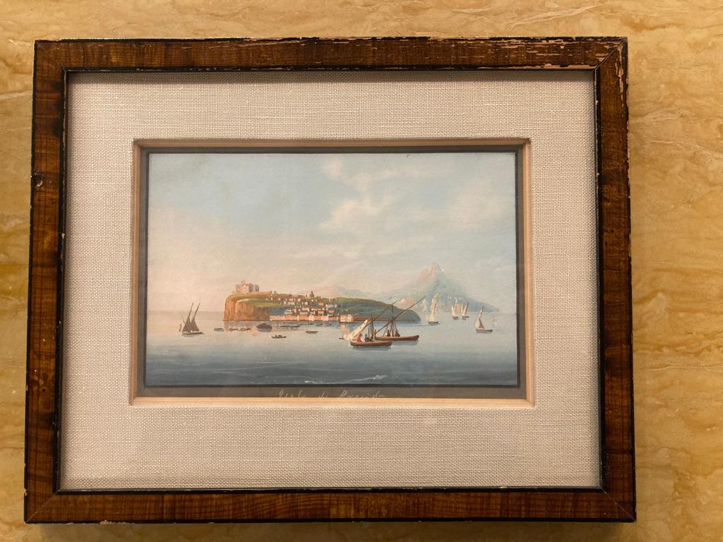 Pair of small scale beautifully detailed gouaches of islands in the bay of Naples, Isola di Nisida and Isola di Procida, with mount Vesuvius in the background. Showing various boats and sailing boats in the bay and people standing on the promenade.