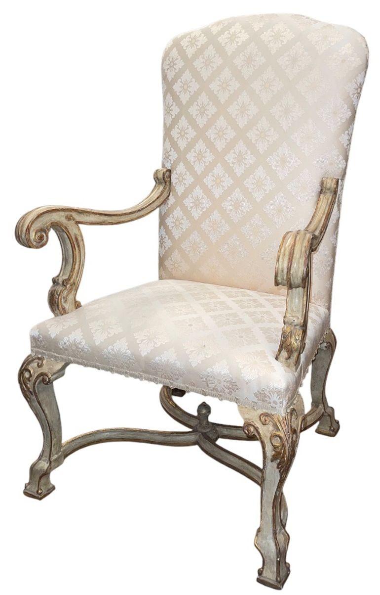 A refined pair of 19th-century Italian armchairs, beautifully carved and retaining traces of their original painted and gilt finish. These elegant chairs feature tall, shaped backs and sweeping scroll arms, gracefully carved in the Italian Baroque