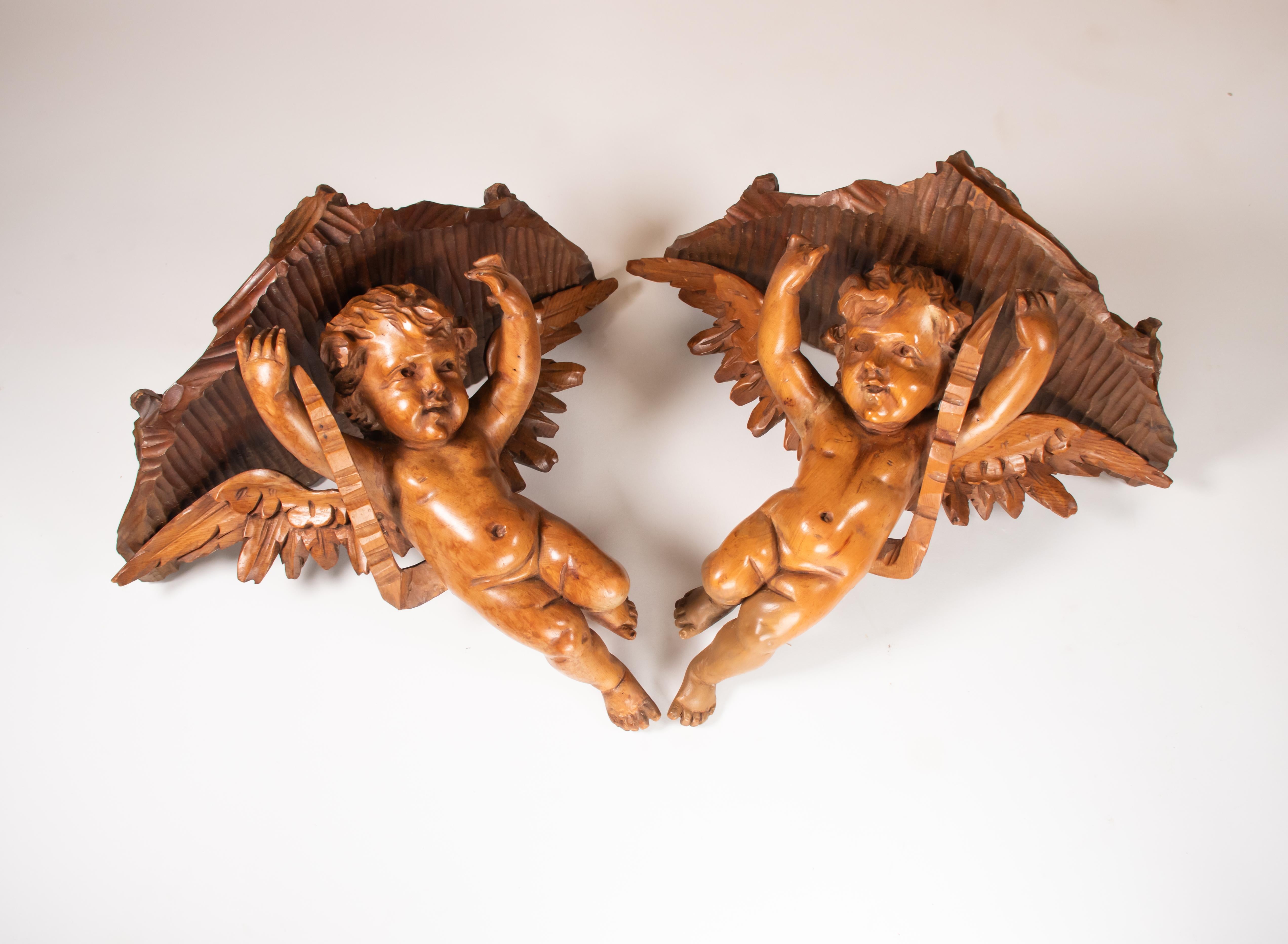 This exquisite pair of 19th-century Italian hand-carved walnut brackets features angels who elegantly support the shelf surface. Designed to hold small lightweight decorative items, they are also striking when displayed alone. These brackets make a