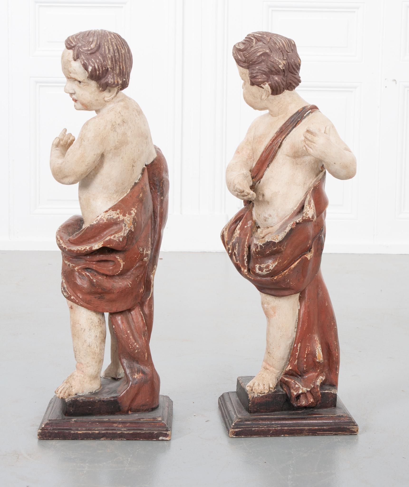 This 19th century Italian pair are hand carved, hand painted and retain their original paint. Not to be confused with cherubs, Putti are the sometimes winged statues or representations of male children and represent secular passion. The pair have