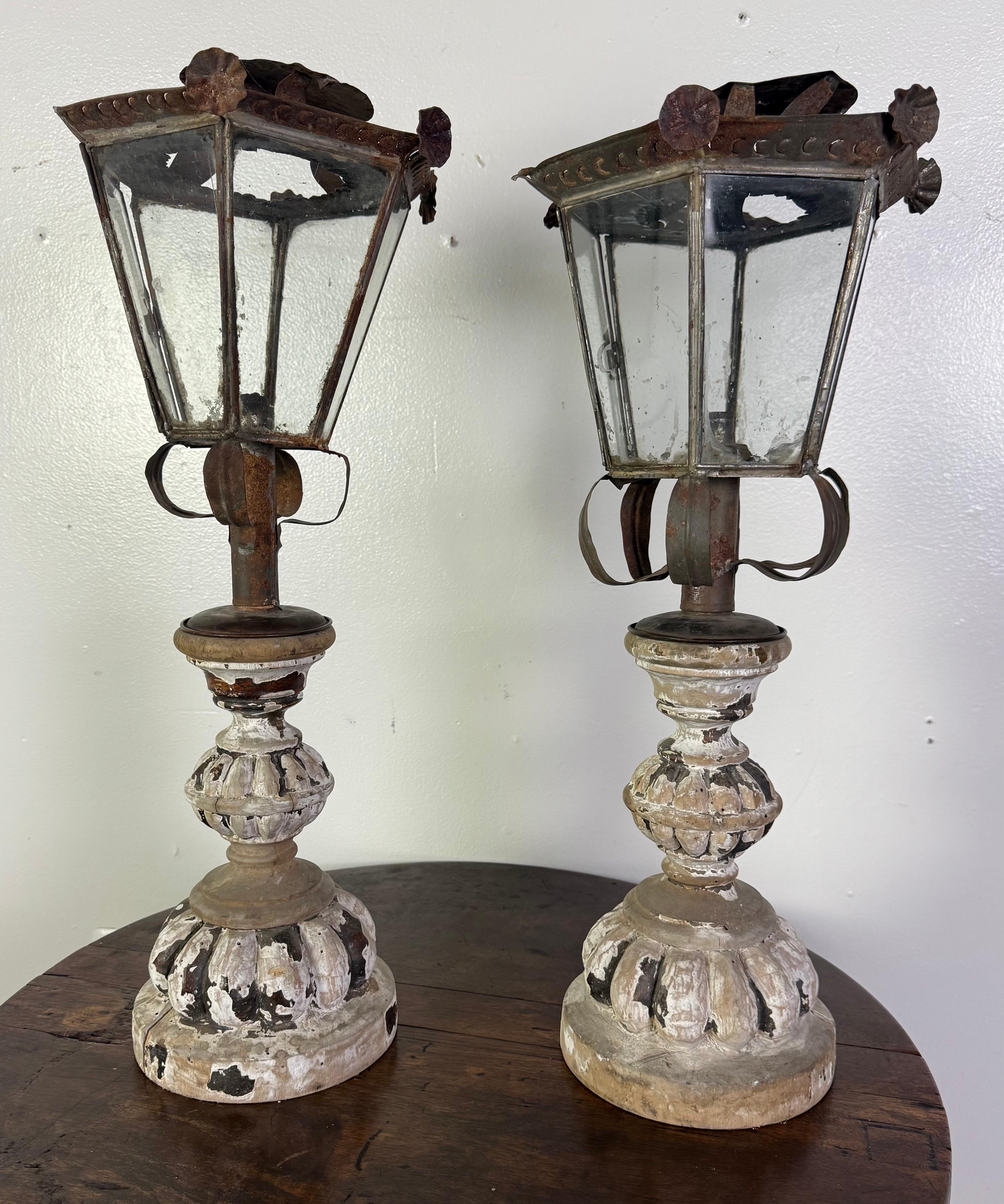 Esta rara pareja de faroles italianos de finales del siglo XIX combina el herraje rústico con bases de madera elegantemente tallada, mostrando el encanto de la artesanía del sur de Europa.

Cada farol tiene un marco de hierro forjado a mano con