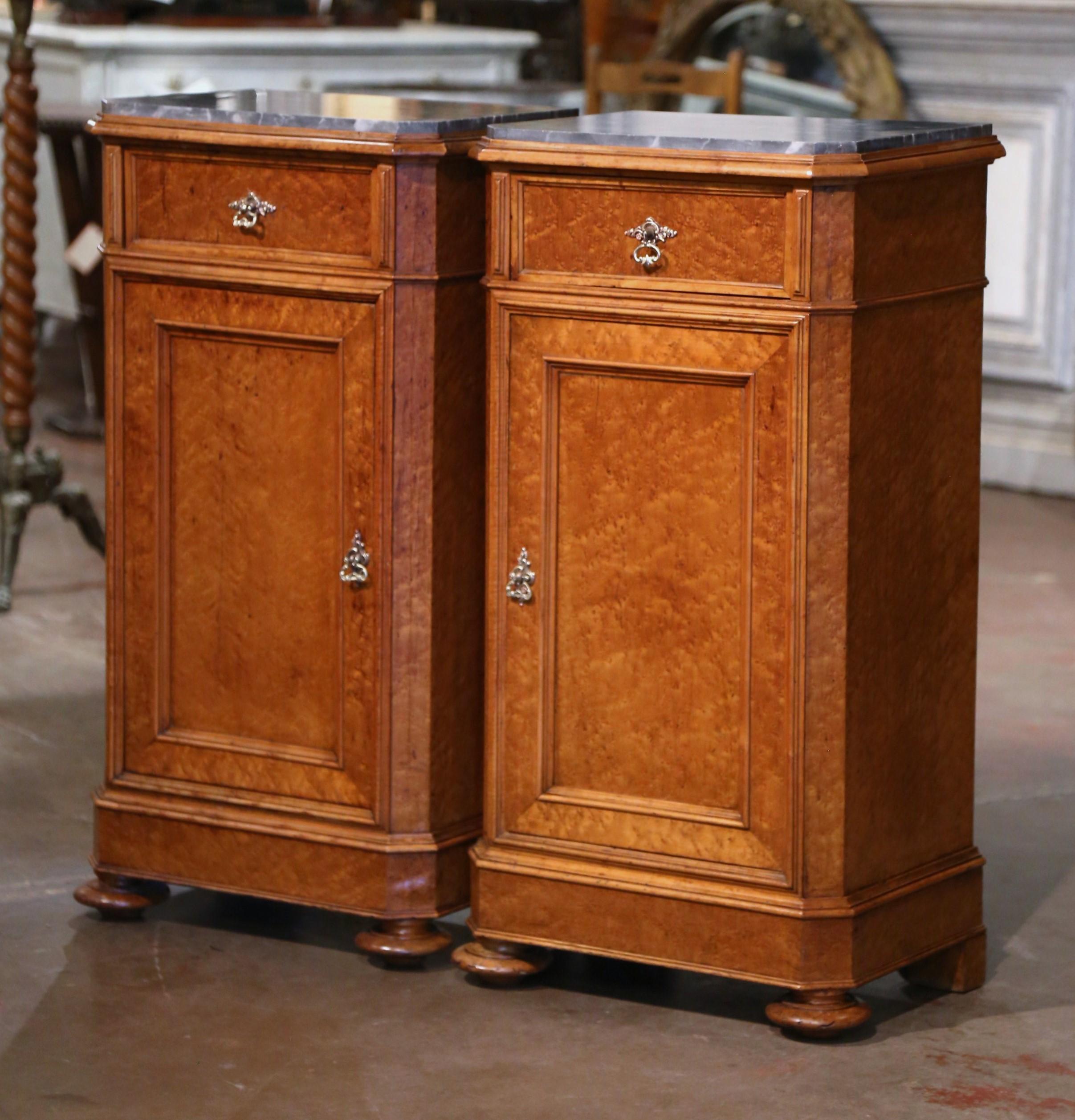 Add surface space in your bedroom with this elegant pair of antique nightstands. Crafted in Genoa, Italy circa 1870, each cabinet built of Birdseye maple, stands on bun feet over a straight plinth base; each traditional piece with clean lines