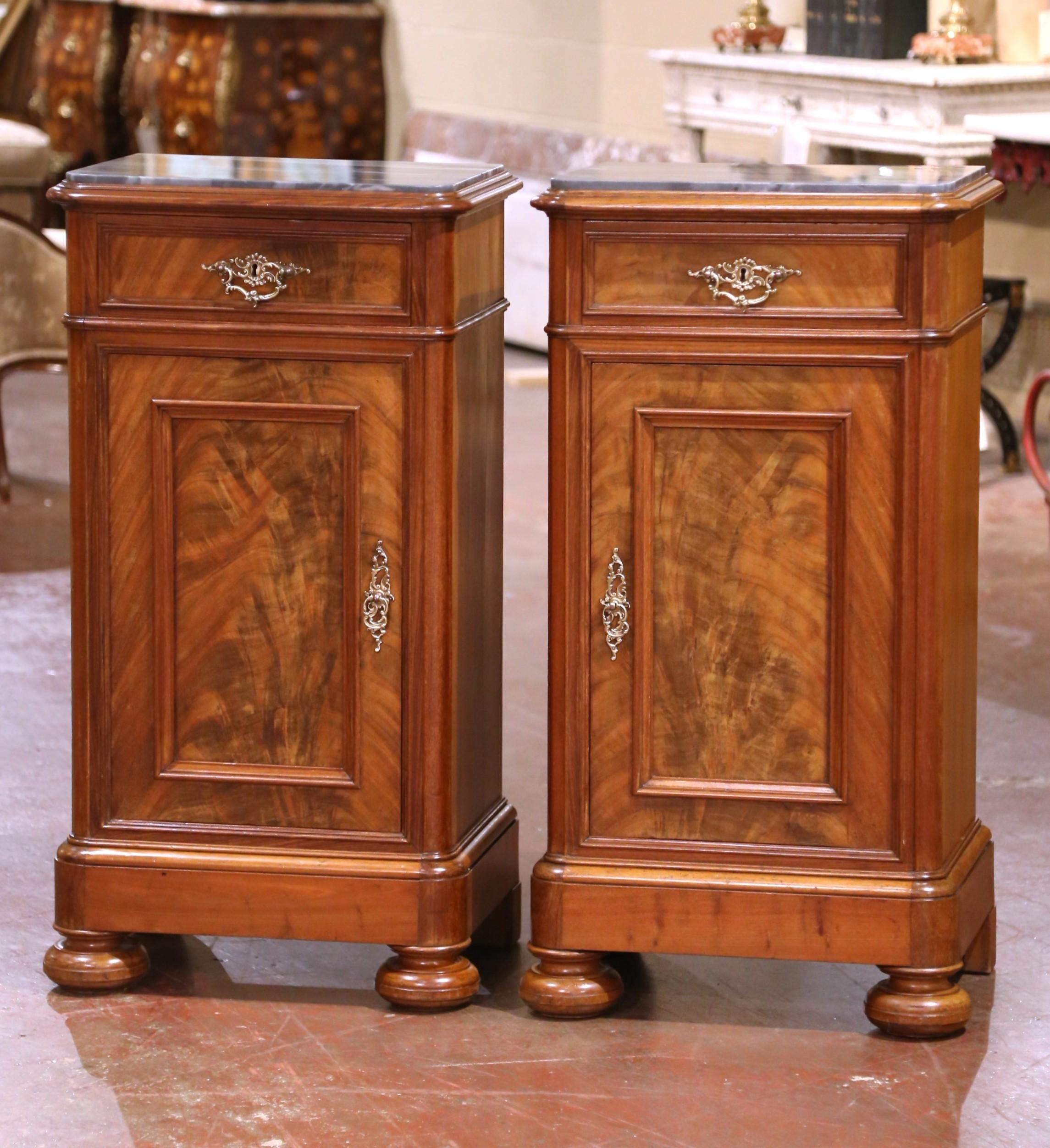 Add surface space in your bedroom with this elegant pair of antique nightstands, crafted in Italy circa 1870. Each piece is made from richly grained walnut, featuring a warm patina. The rectangular tops are crowned with luxurious gray marble,