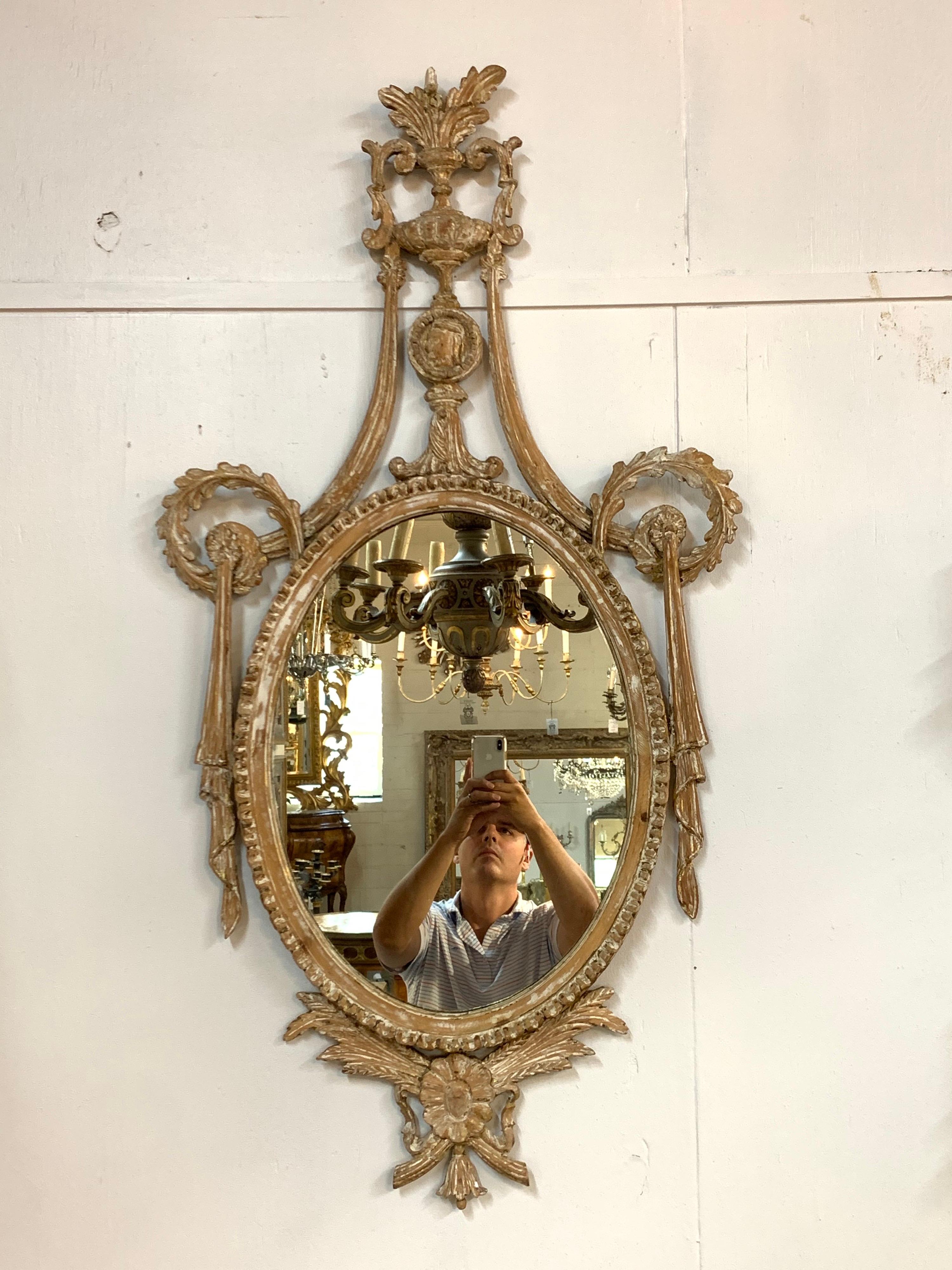 Fabulous pair of 19th century Italian neoclassical carved and white washed mirrors. Carvings including floral images, an urn and a bow. Makes a gorgeous accessory for a fine home!