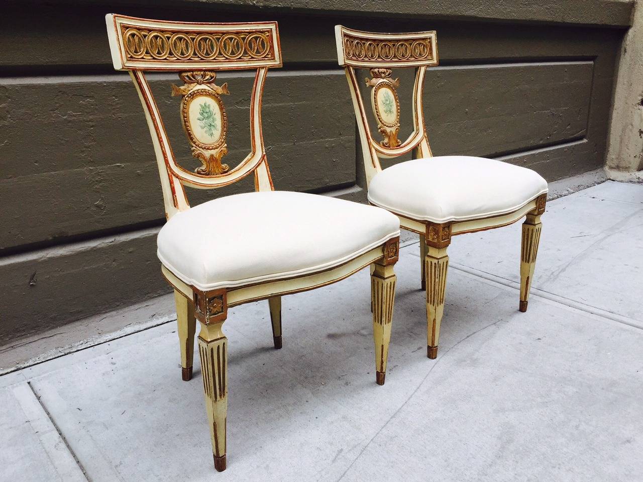 Pair of 19th century Italian neoclassical side chairs. Gold leaf and painted wood frame with linen upholstered seats.
    