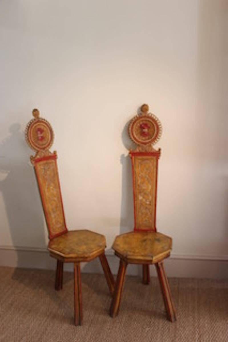 A wonderfully decorative pair of 19th century Italian painted hall chairs with ornate painted decoration that would make a statement in most settings.
   
