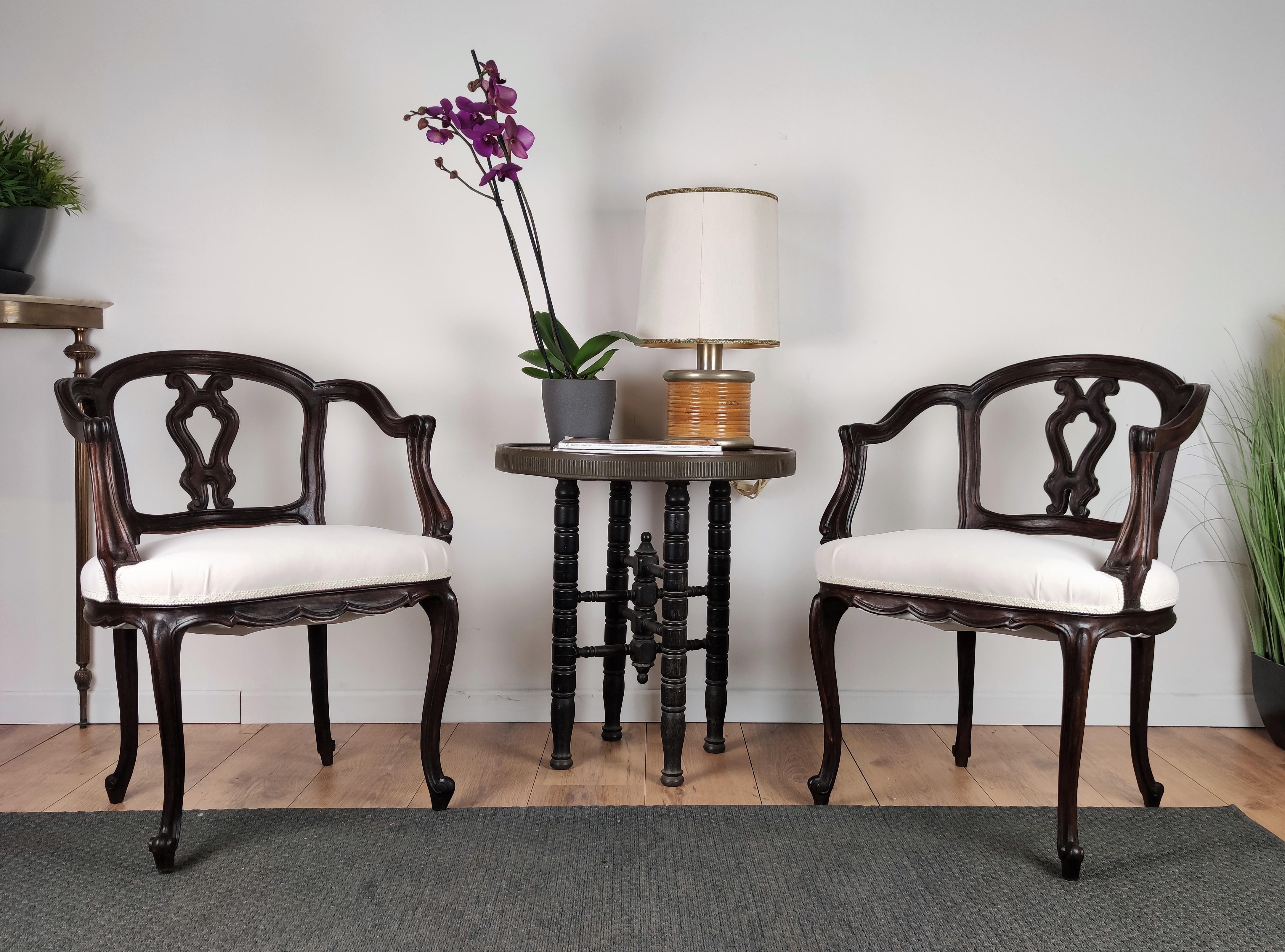 Beautiful pair of Italian 19th century carved wood armchairs in Rococo Baroque style newly upholstered in white fabric with very elegant shape and great color of wood to highlight the detailed decors and frame of the legs, sides and back.
 