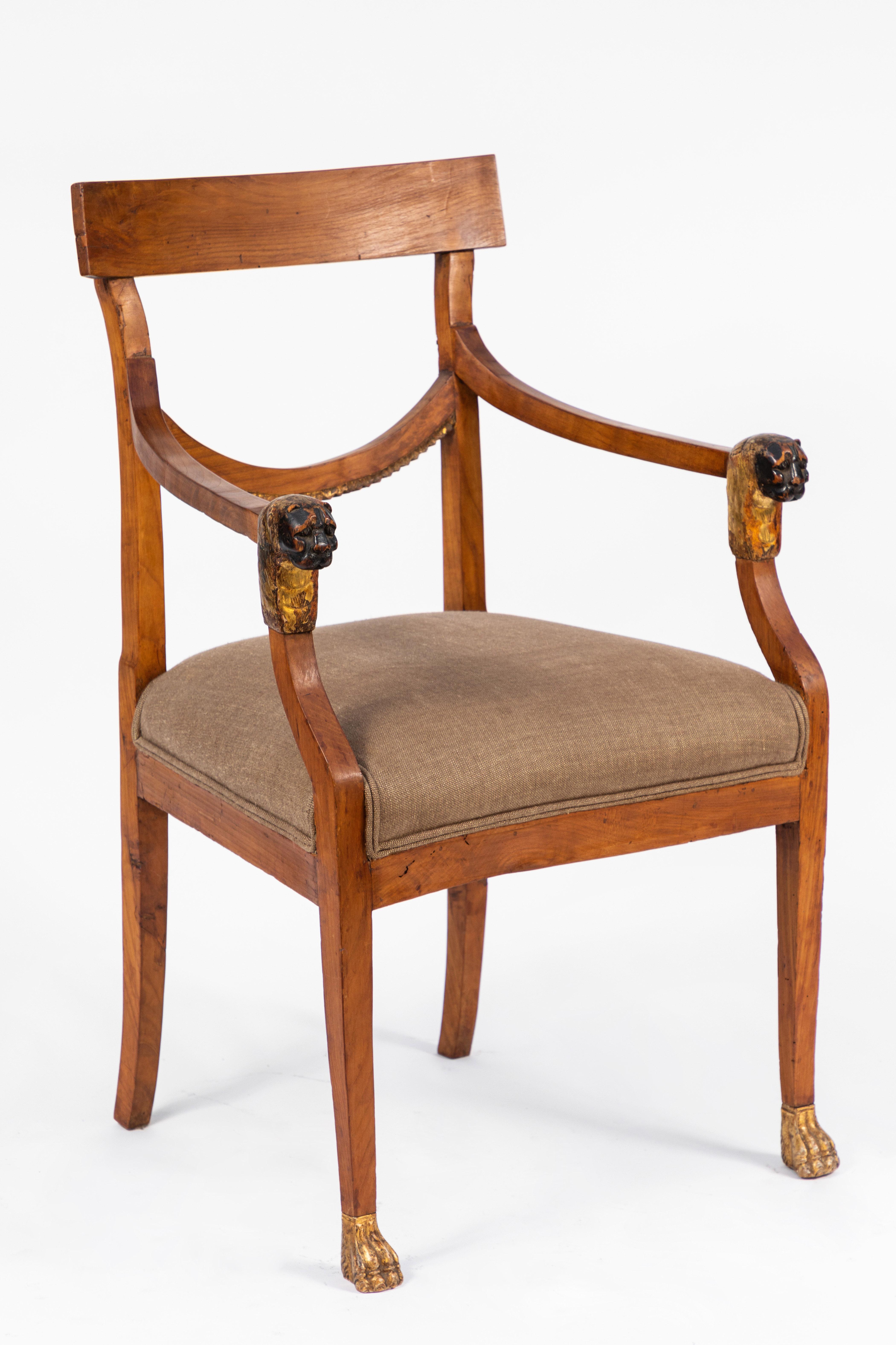 Pair of 19th century Italian walnut armchairs with carved giltwood details. Carved lion's head and paw motif.
