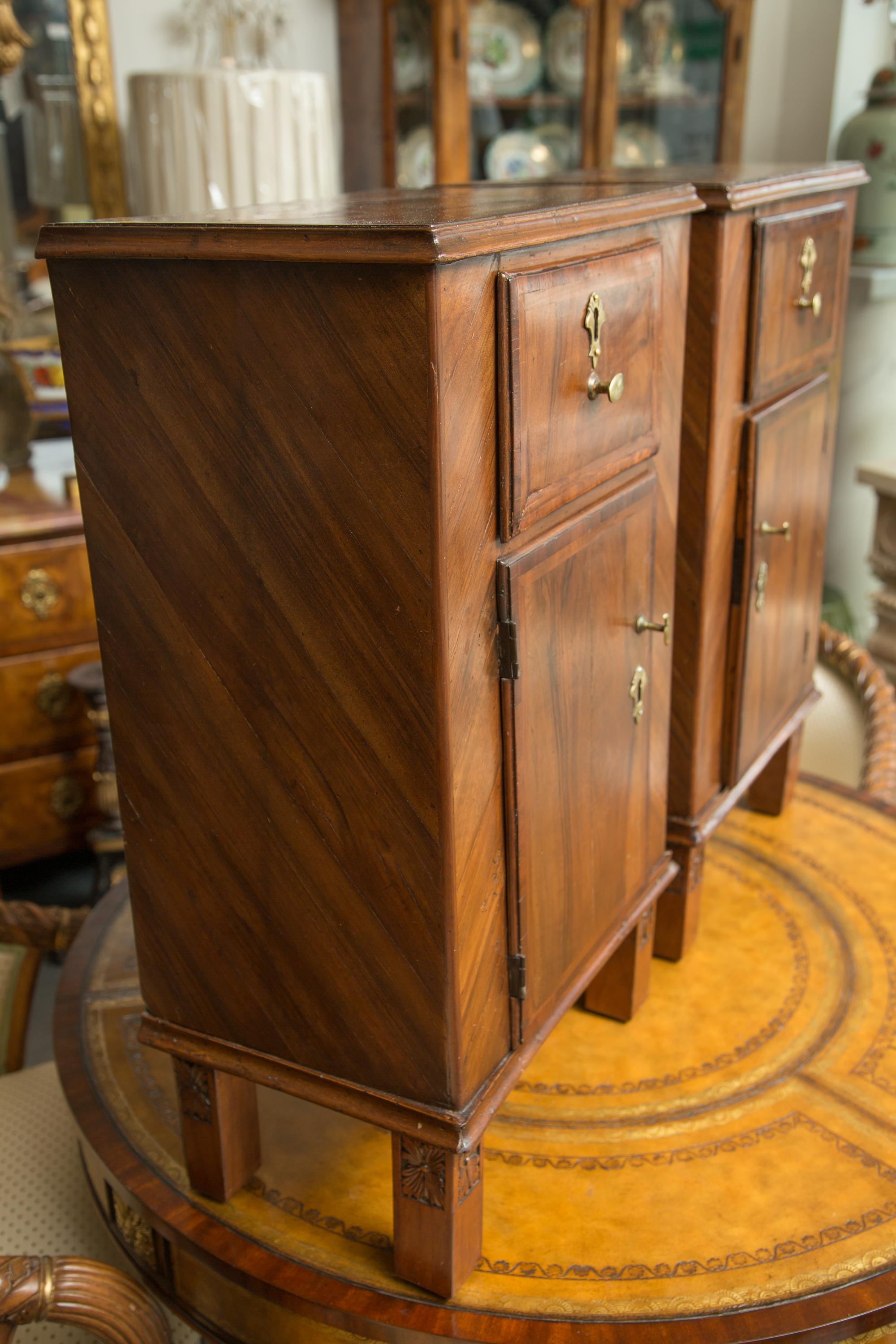 This is a pair of Italian walnut bedside cabinets, the top with molded edge over a single drawer and cabinet door. Supported by straight legs, late 19th century.