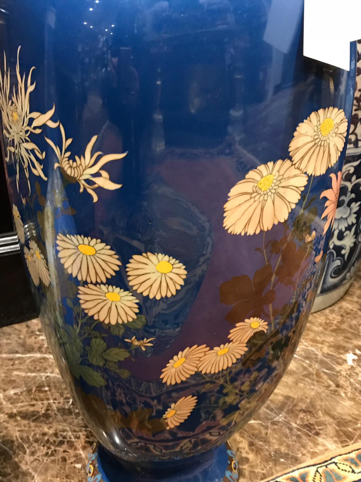 A pair of dark blue cloisonné square shaped tapering vases with flaring necks. Beautiful pair from the Meiji period. They are decorated with depictions of a variety of flowers including: Large white chrysanthemums, pink peonies and other pink and