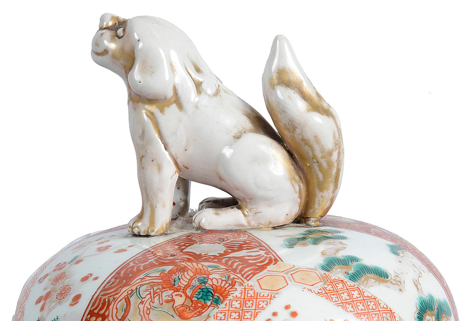A good quality pair of lidded Japanese 19th century Imari vases, each having a dog of faux finials, classical motif, exotic flowers and bird decoration, mounted on carved fretwork wooden stands.