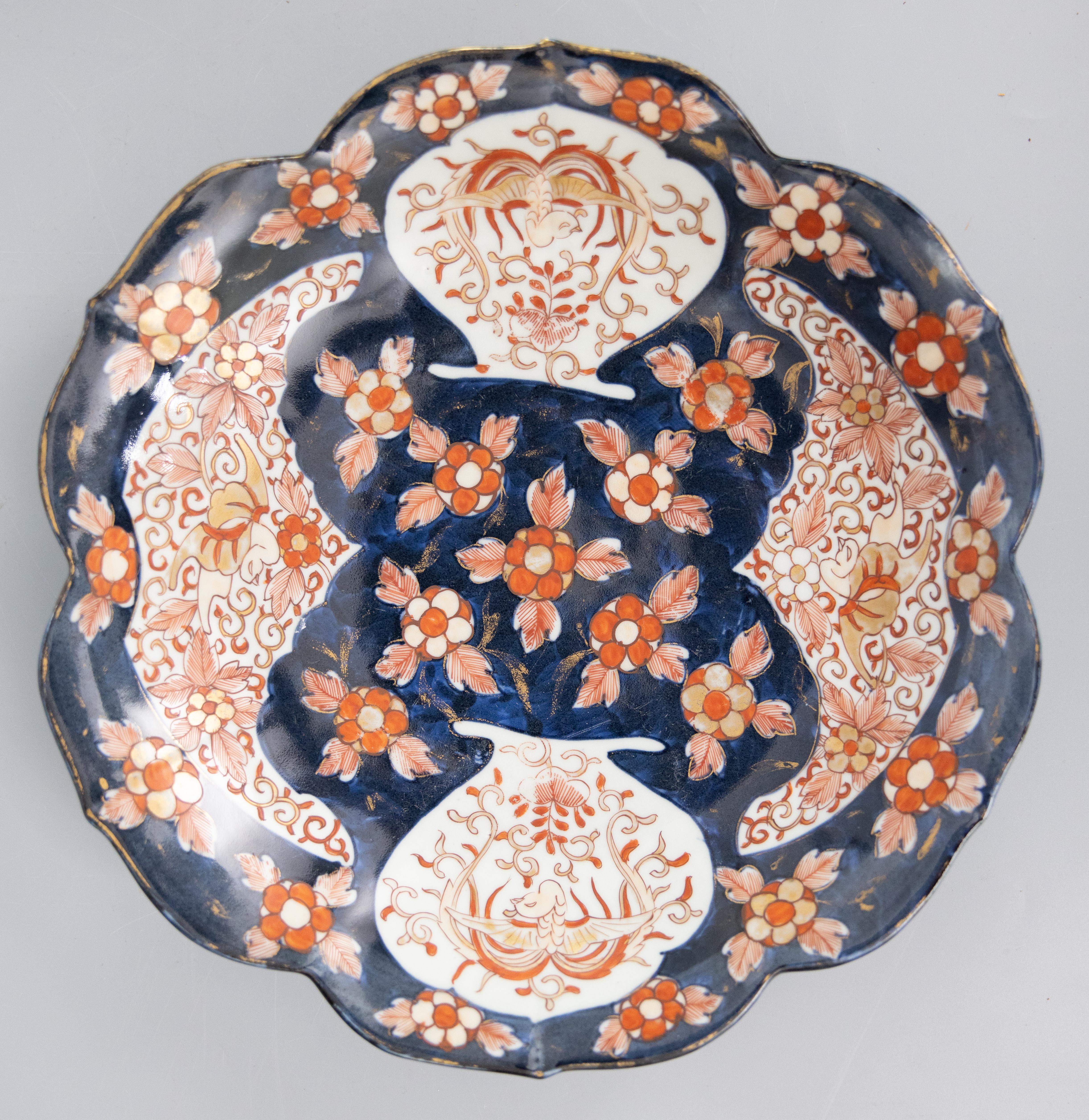 Ein prächtiges Paar japanischer Imari-Porzellanteller aus der Meiji-Zeit des 19. Jahrhunderts in Dunkelblau. Diese feinen, großen Teller haben einen schönen, gebördelten Rand und handgemalte Blumendekorationen in den traditionellen Imari-Farben. Sie