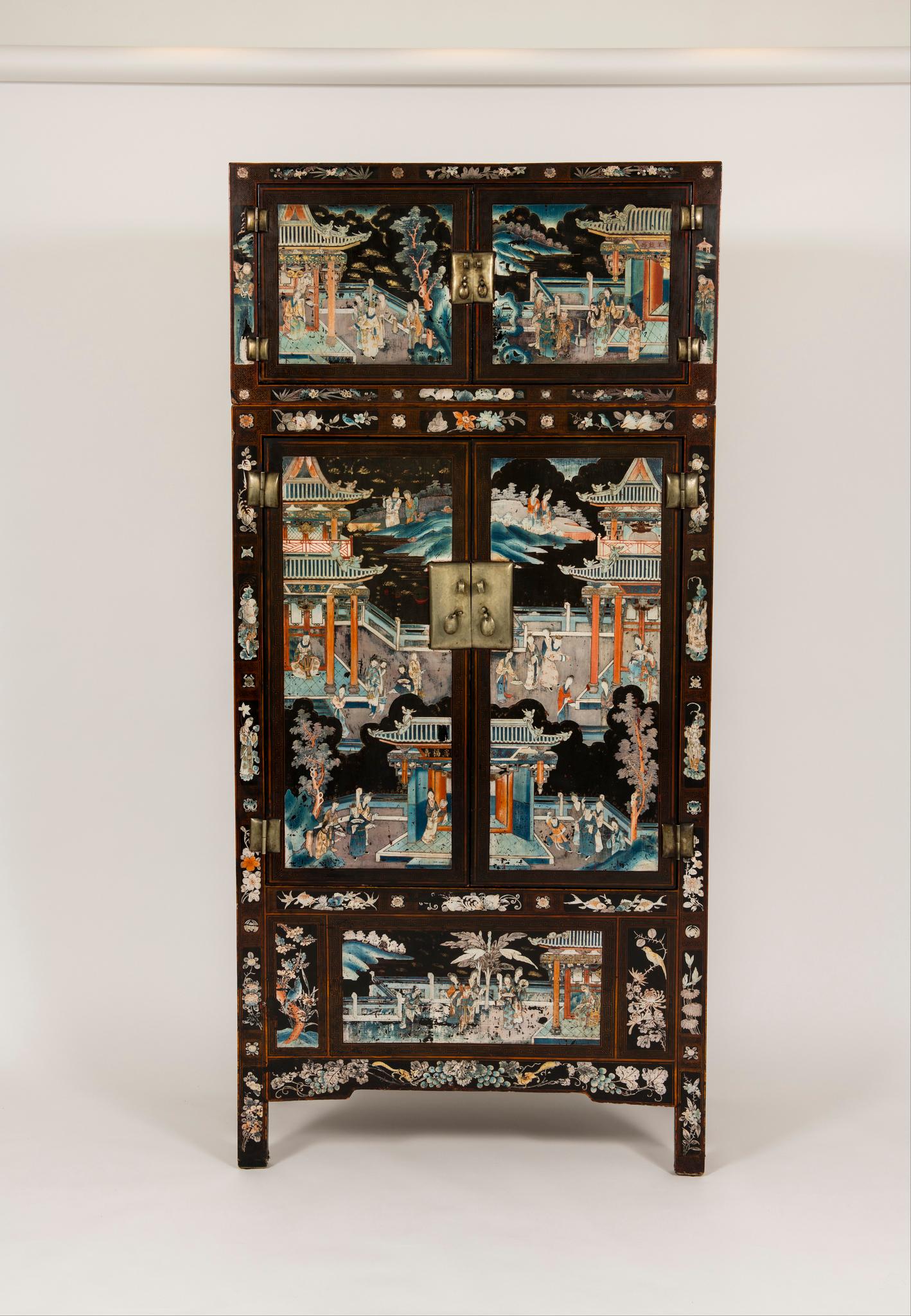 A spectacular pair of early 20th century Chinese lacquered Ming style compound cabinets with painted scenes of figures in a temporal garden landscape. Still vividly colored, the lavish decorations cover the cabinets from top to bottom, complemented