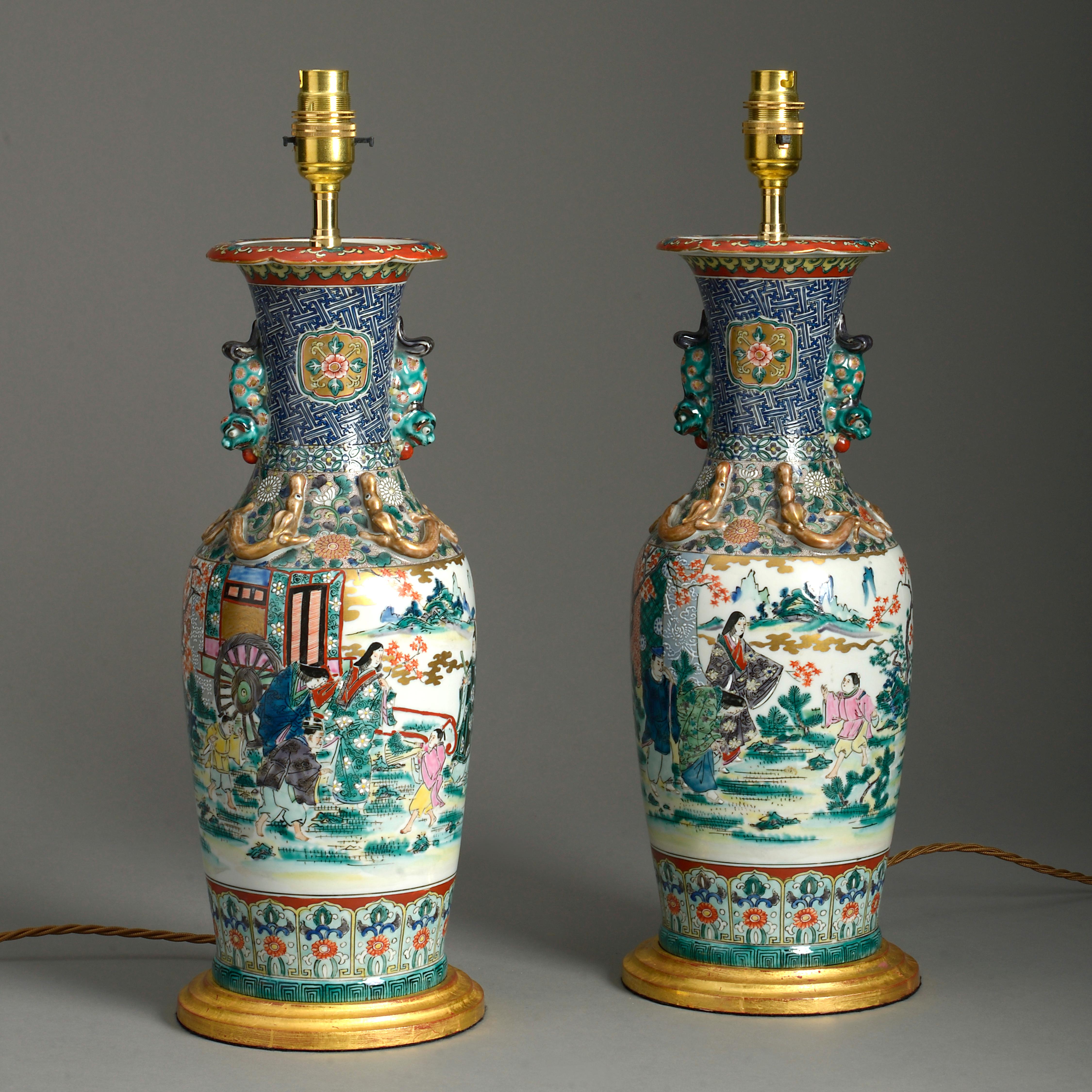 A pair of late 19th century Meiji Period polychrome glazed porcelain Kutani vases, decorated with figurative scenes, the bodies having applied handles and gilded dragons.

Now wired as table lamps and mounted upon turned giltwood