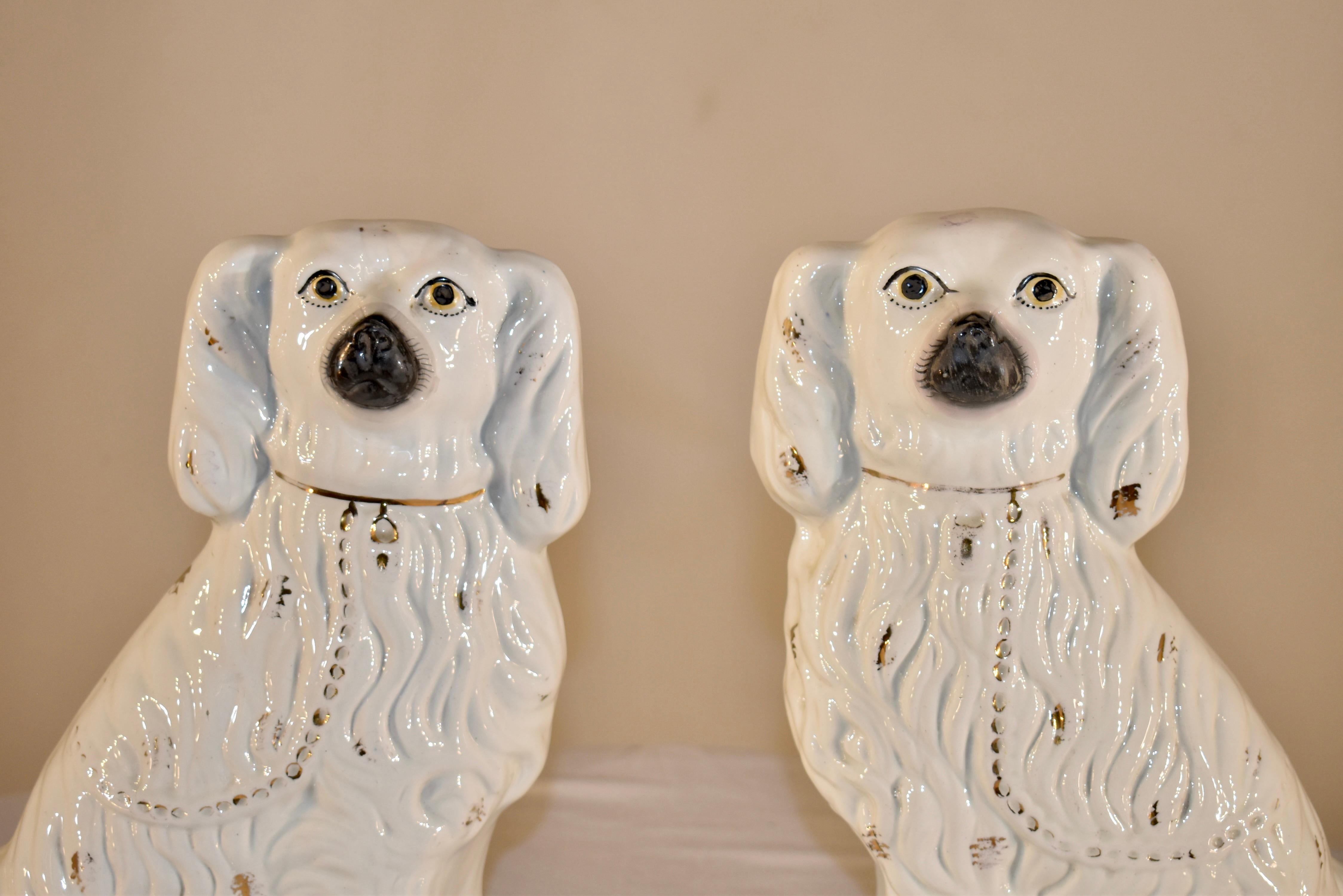 Pair of enormous 19th century Staffordshire spaniels from England. This pair of dogs are wonderfully detailed and are magnificent in stature. They have gorgeous faces and are decorated with gold lustre spotting.